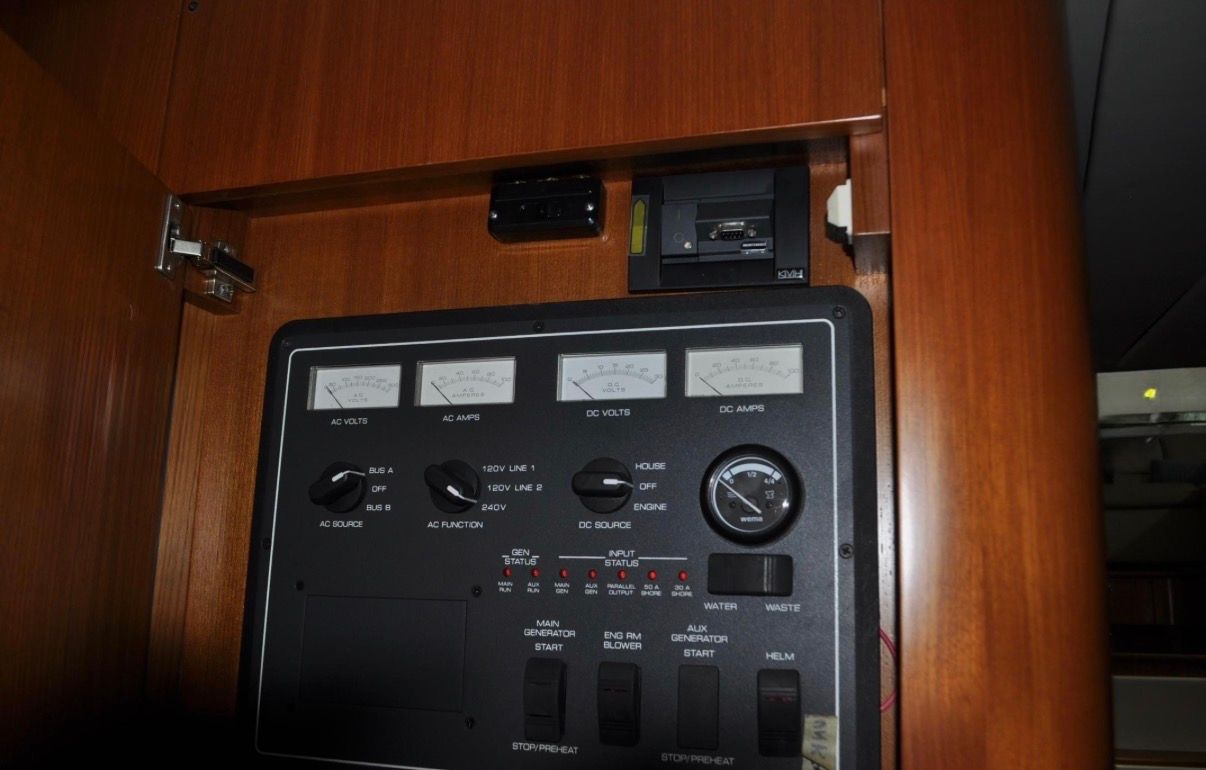 Electrical control panel with gauges and switches in a wooden frame.