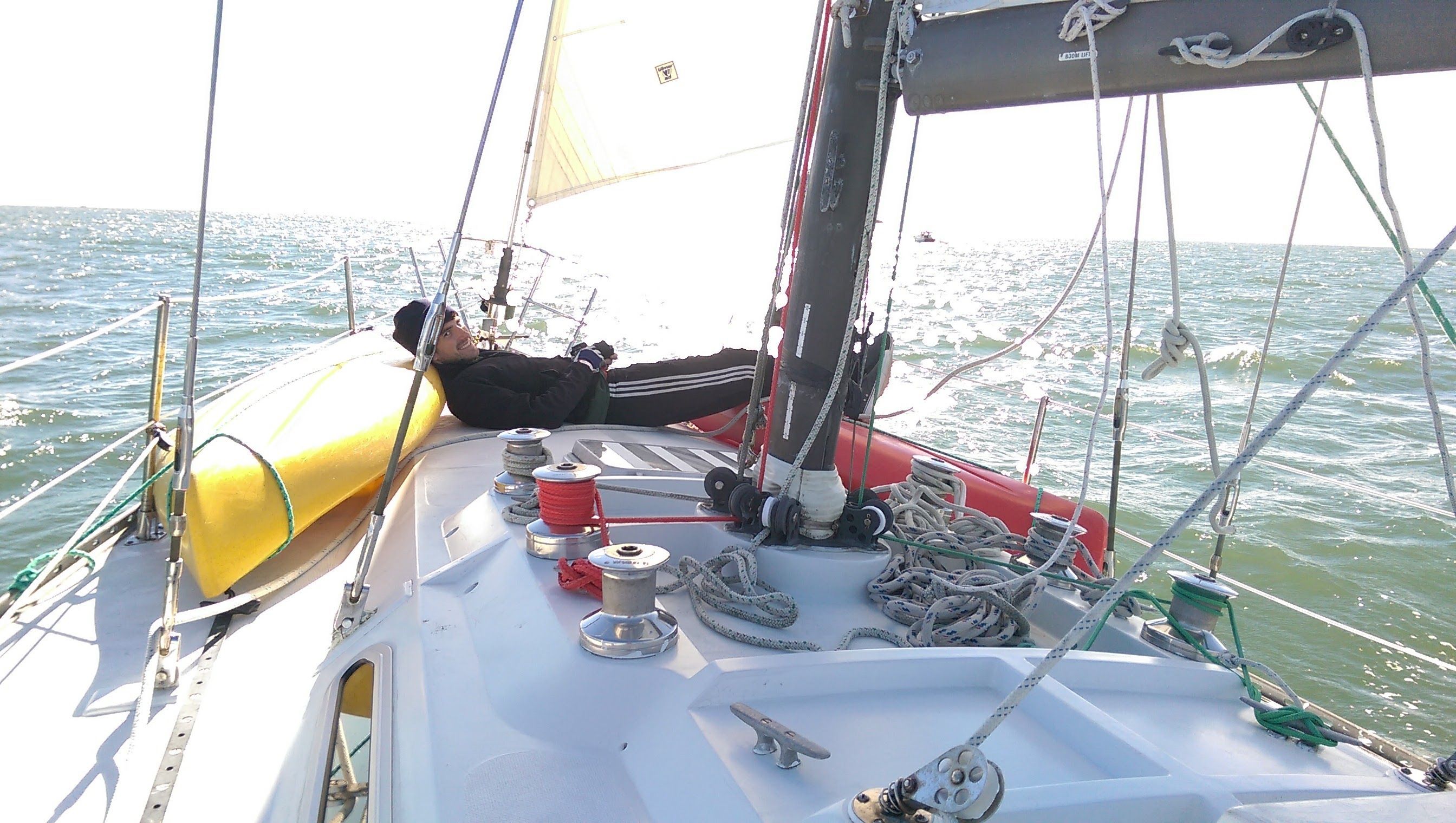 Person relaxing on a 1974 Ericson Racer/Cruiser sailboat.