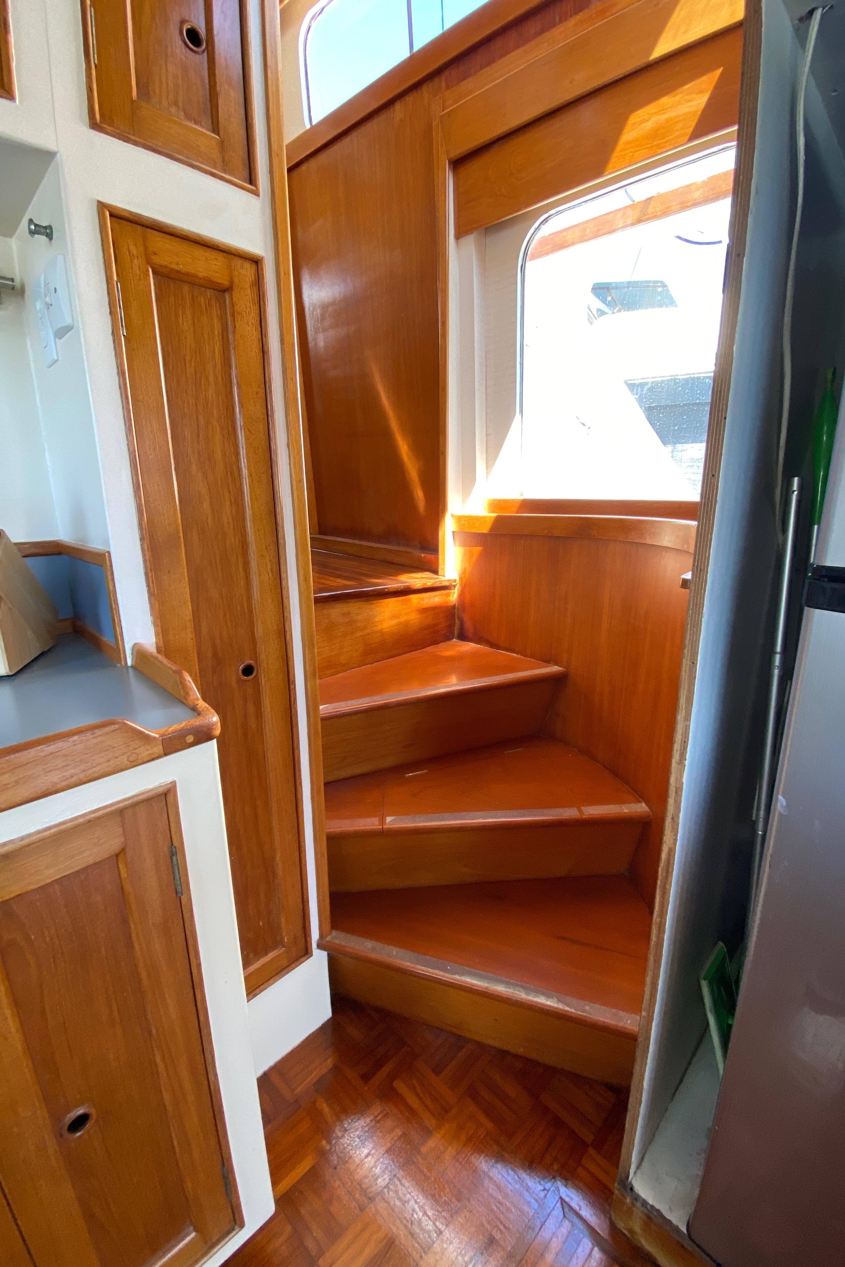 Wooden staircase in 1977 Grand Alaskan Raised Pilothouse yacht interior.