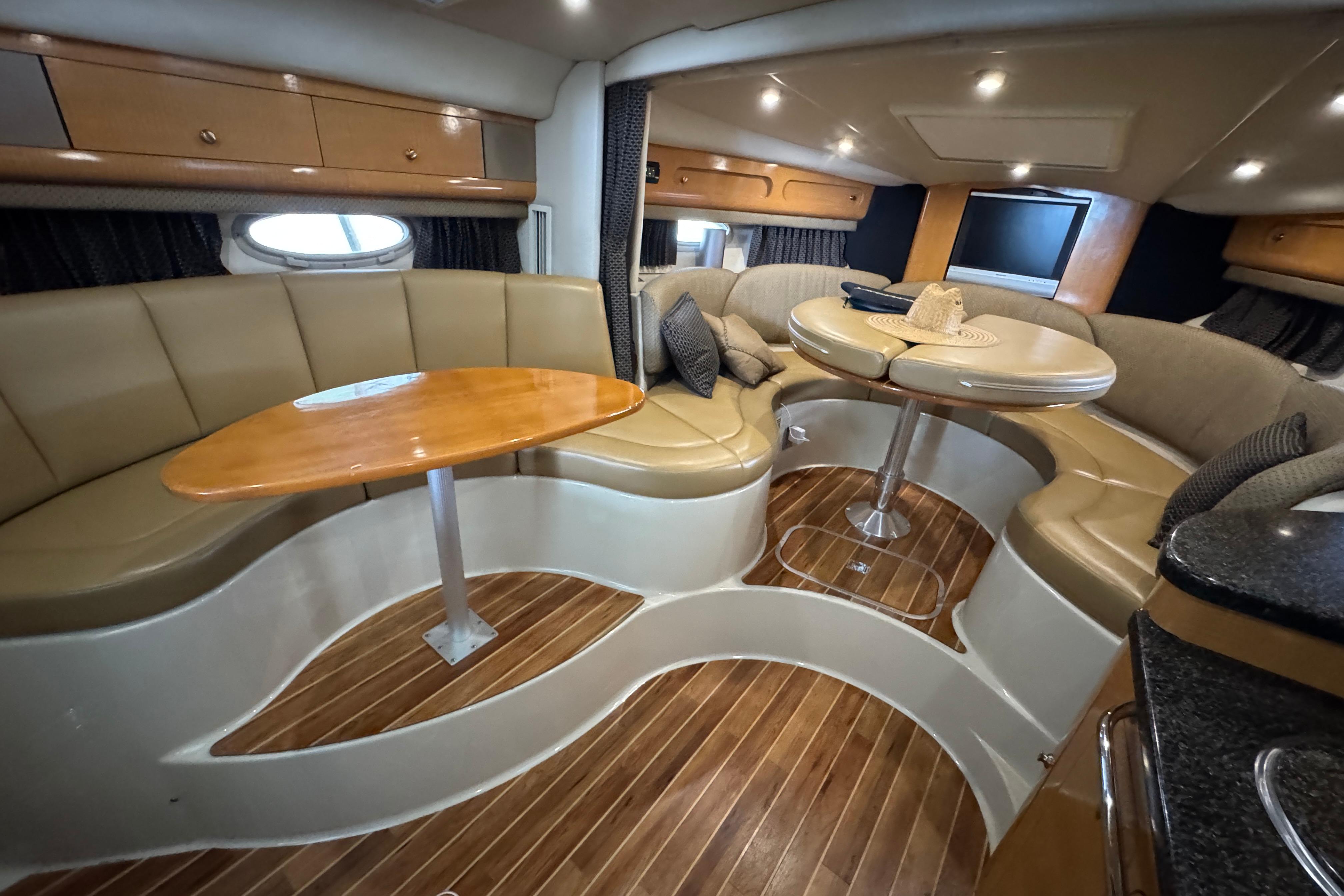 Luxurious interior of 2006 Chaparral 330 Signature yacht with elegant seating and wooden flooring.