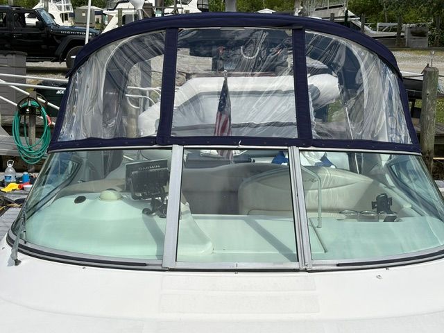 The 2005 Sea Ray Sundancer 280 is docked with a clear cover and visible instruments.