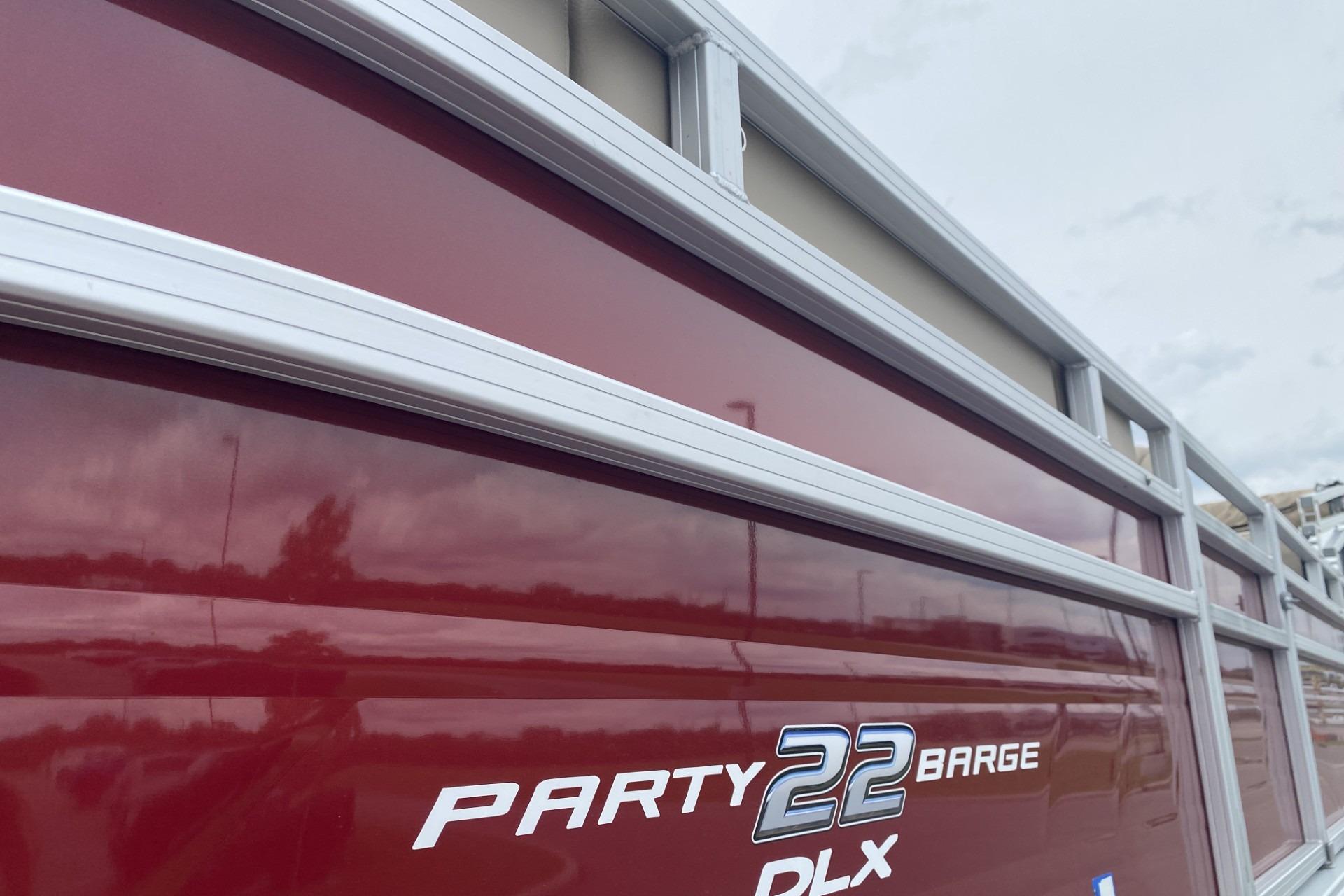 2024 Sun Tracker Party Barge 22 DLX, red exterior with silver accents, side view.