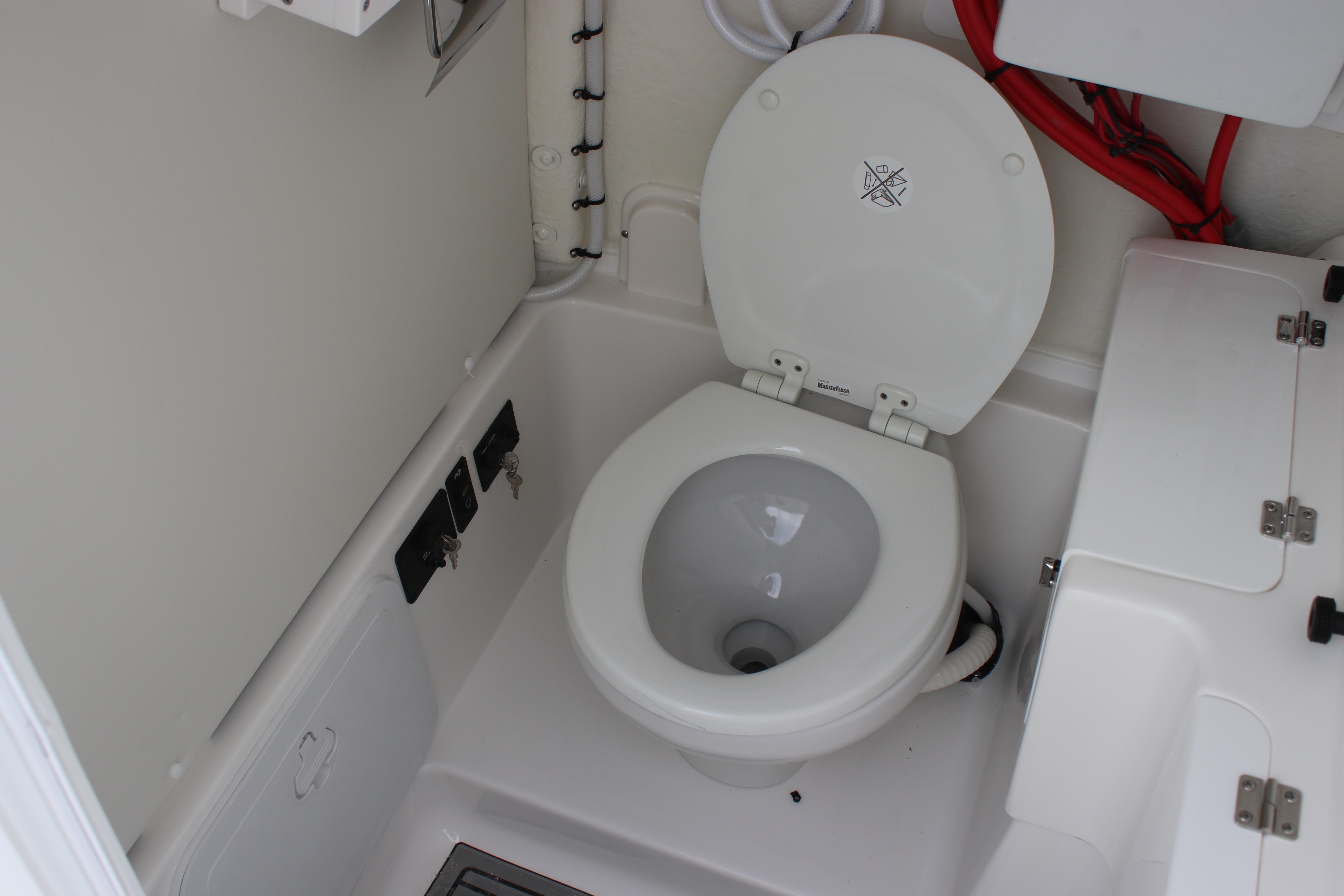 2026 Tidewater 272 LXF boat interior with marine toilet and storage compartments.