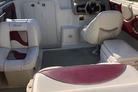 Interior of a 1999 Rinker 212 Fiesta Vee boat with white and red seating.