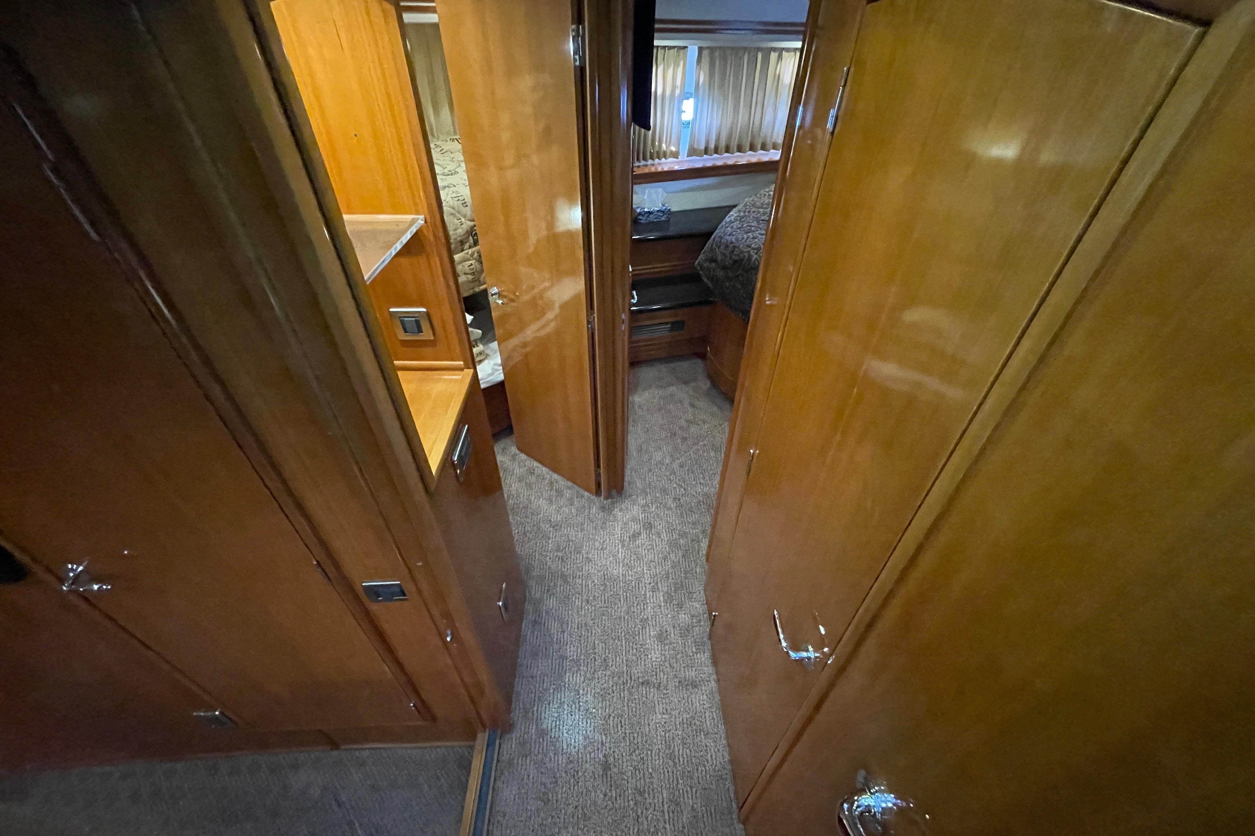 Interior hallway of 2002 Carver 570 Voyager Pilothouse with wooden cabinetry and carpet flooring.