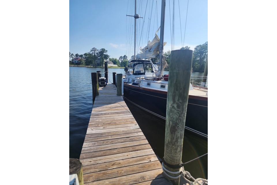 1984 Bristol 45.5 Center Cockpit sailboat docked at a wooden pier.