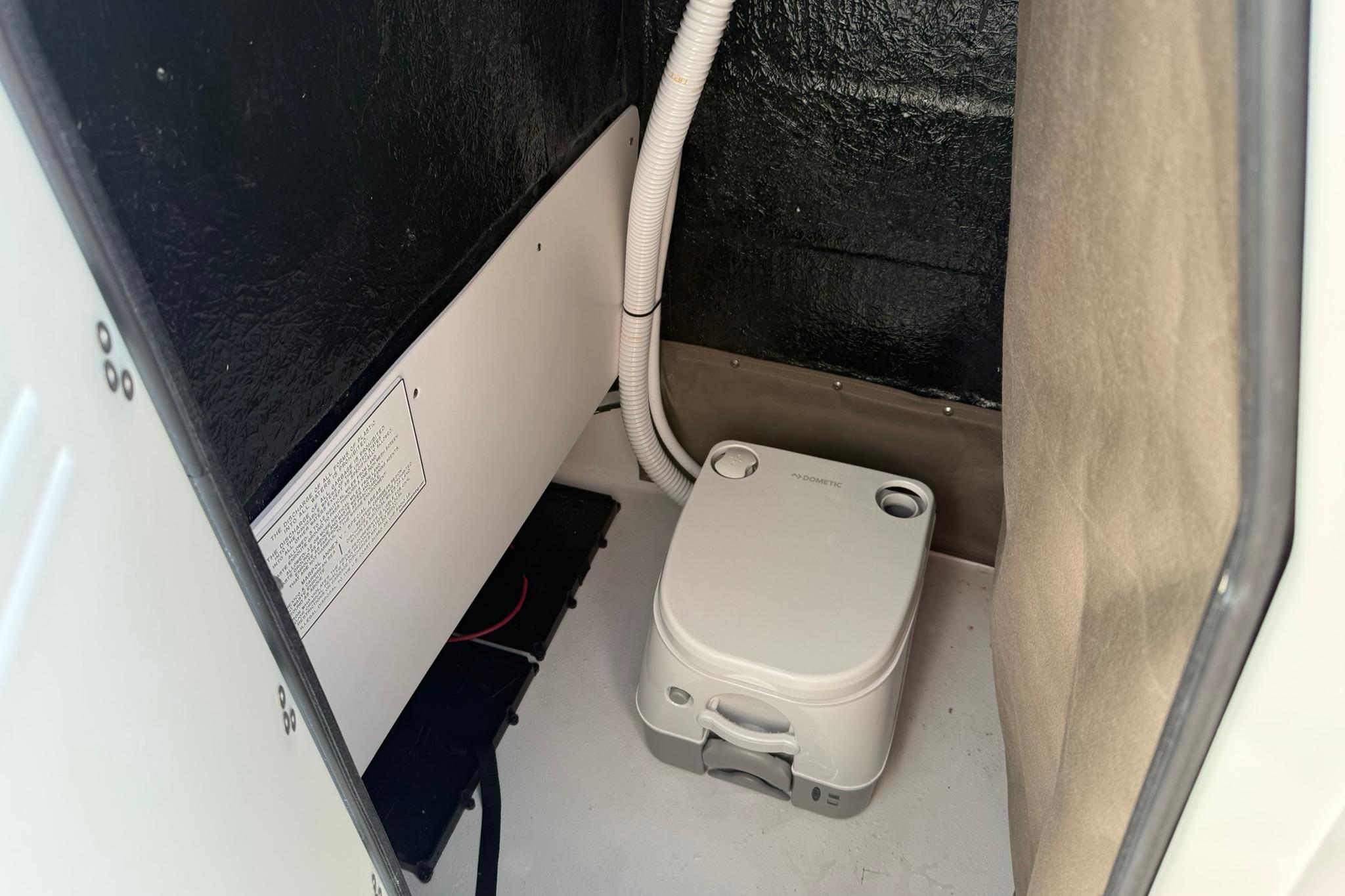 Portable toilet inside 2026 Stingray 173 CC boat compartment.