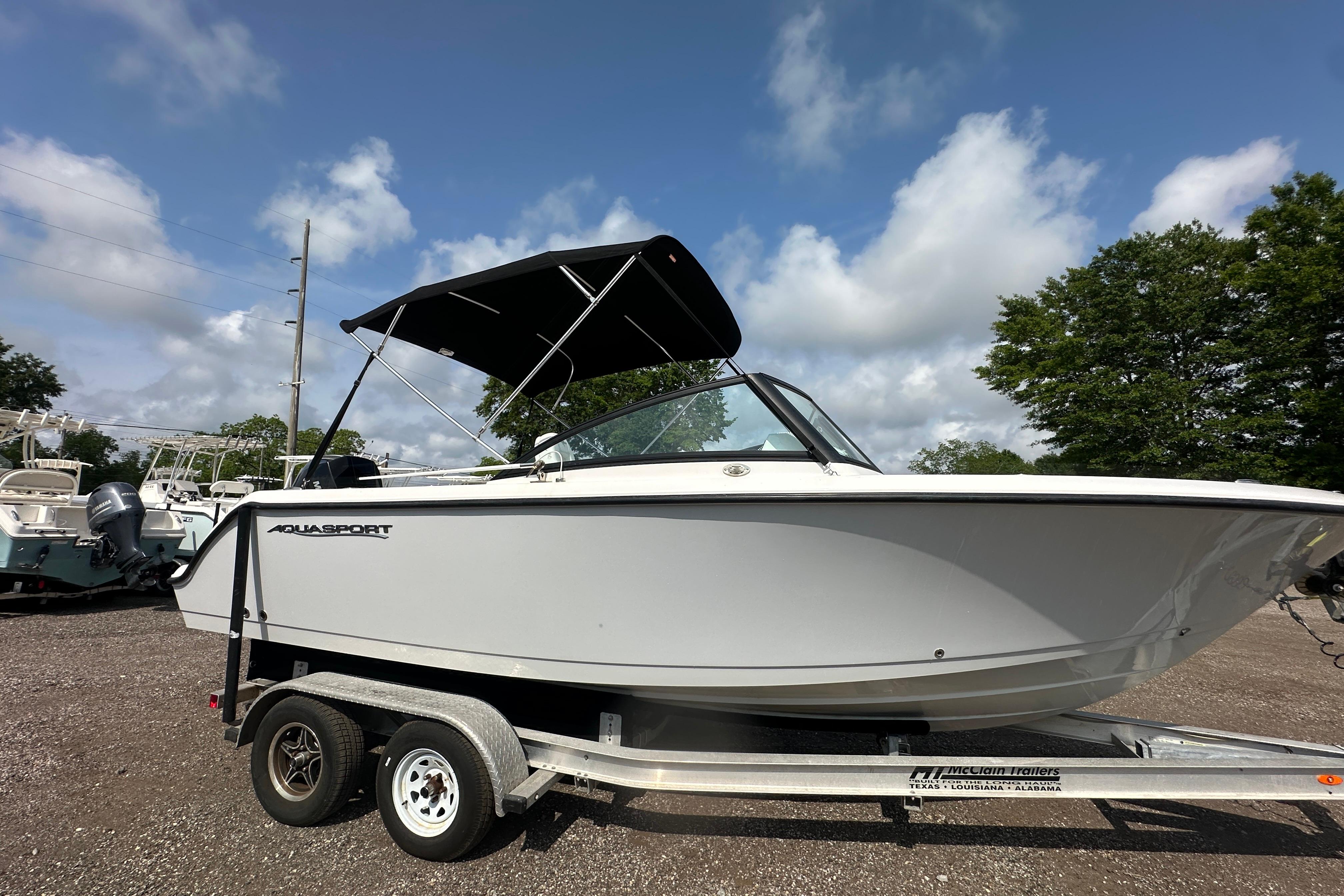 2024 Aquasport 2200 Dual Console boat on trailer under blue sky.