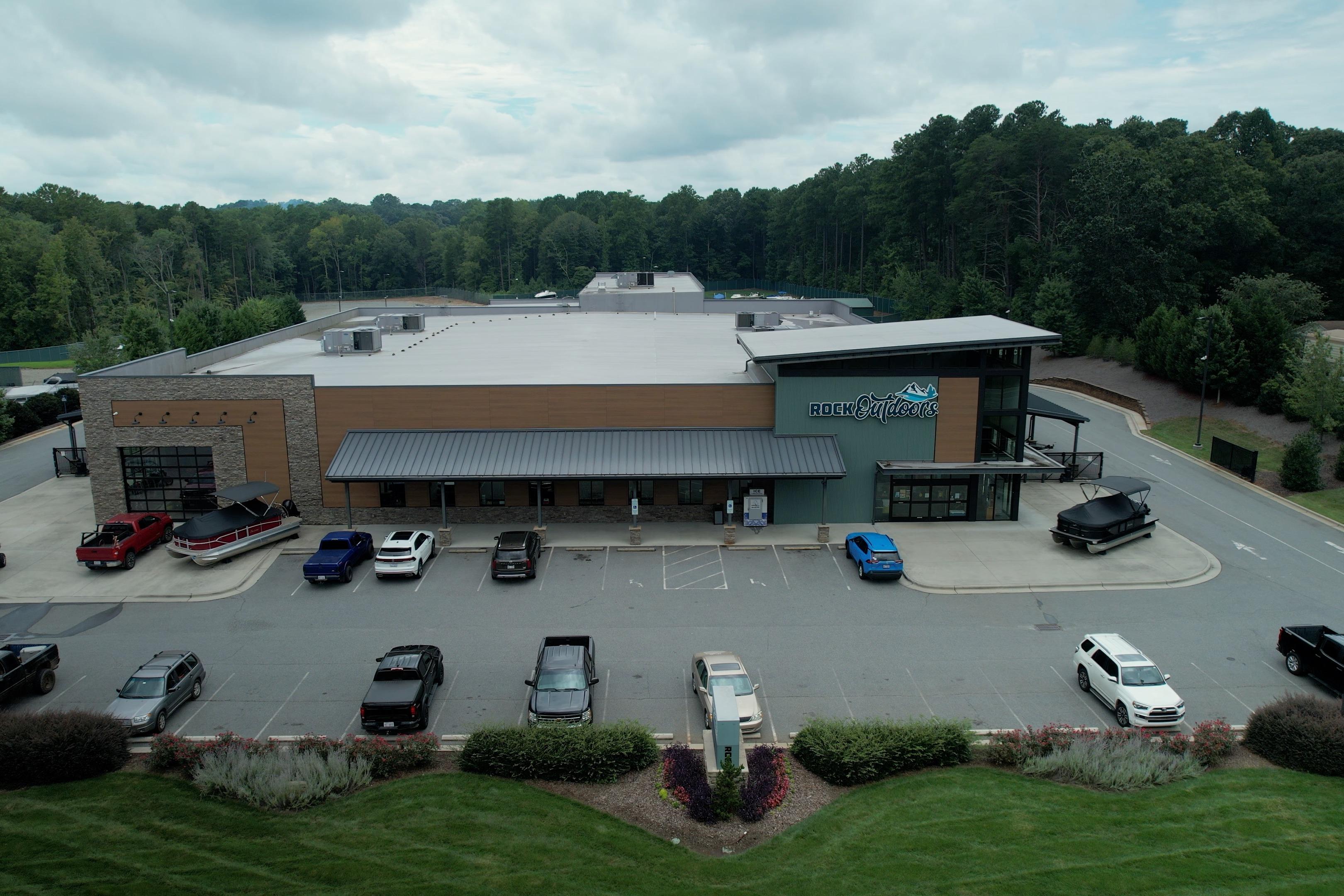 Aerial view of Rock Outdoors store with parked vehicles, including a 2026 Bass Cat Cougar FTD SP.