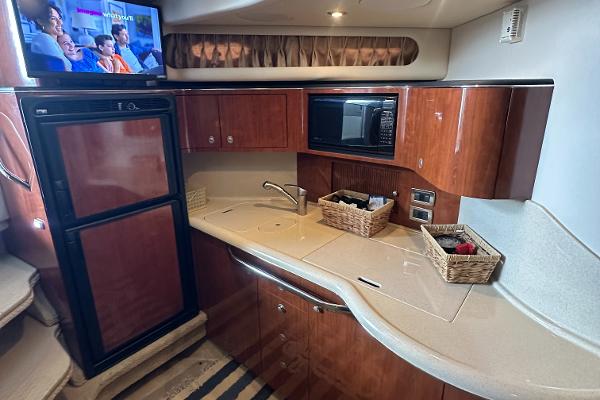 Luxurious 2004 Sea Ray 380 Sundancer yacht kitchen with wood cabinets and modern appliances.