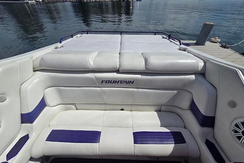 2004 Fountain 38 Lightning boat interior with white and purple seating by the water.