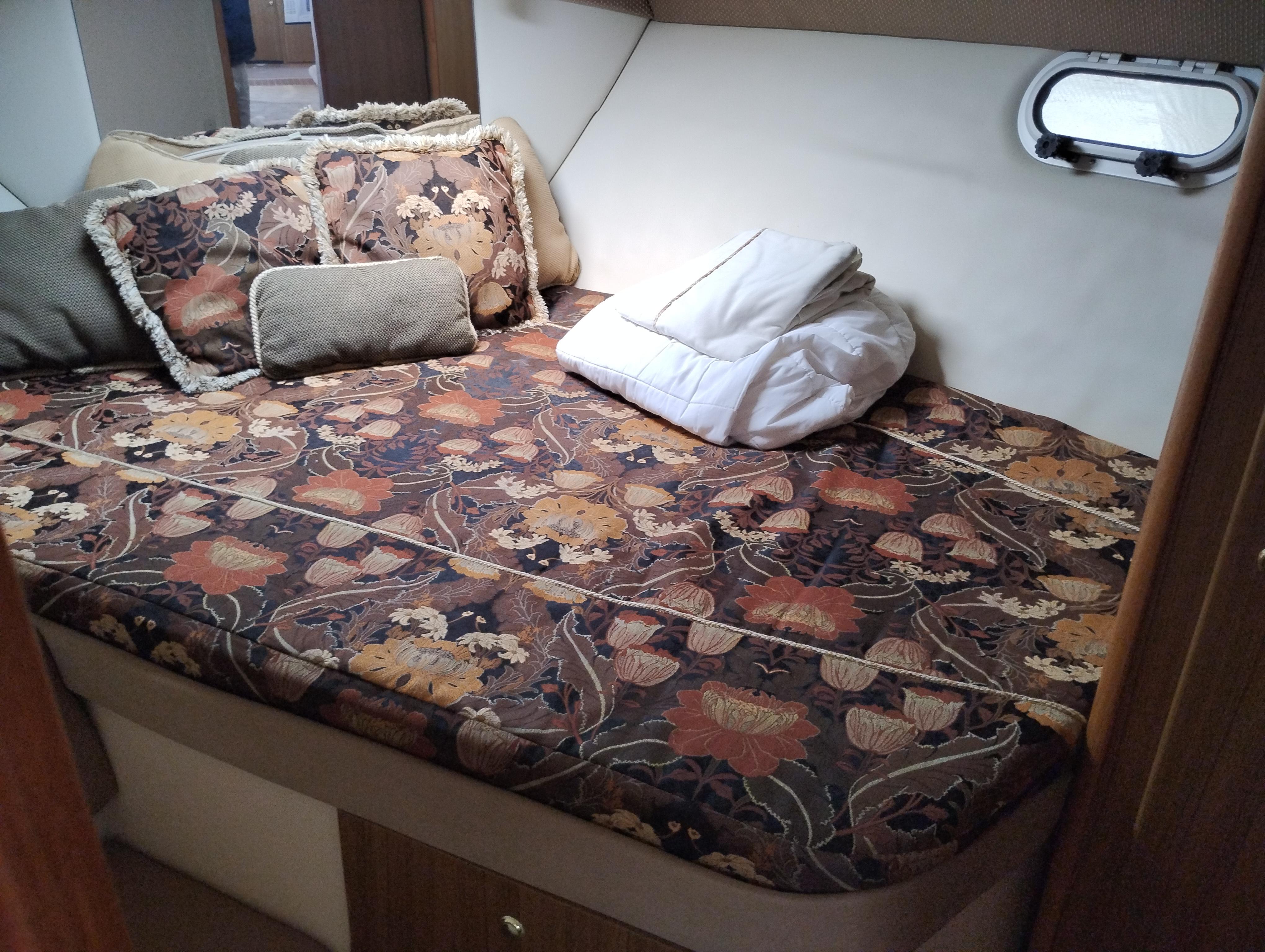 Cozy cabin bed with floral bedding in 2001 Bayliner 3488 Command Bridge Motoryacht.