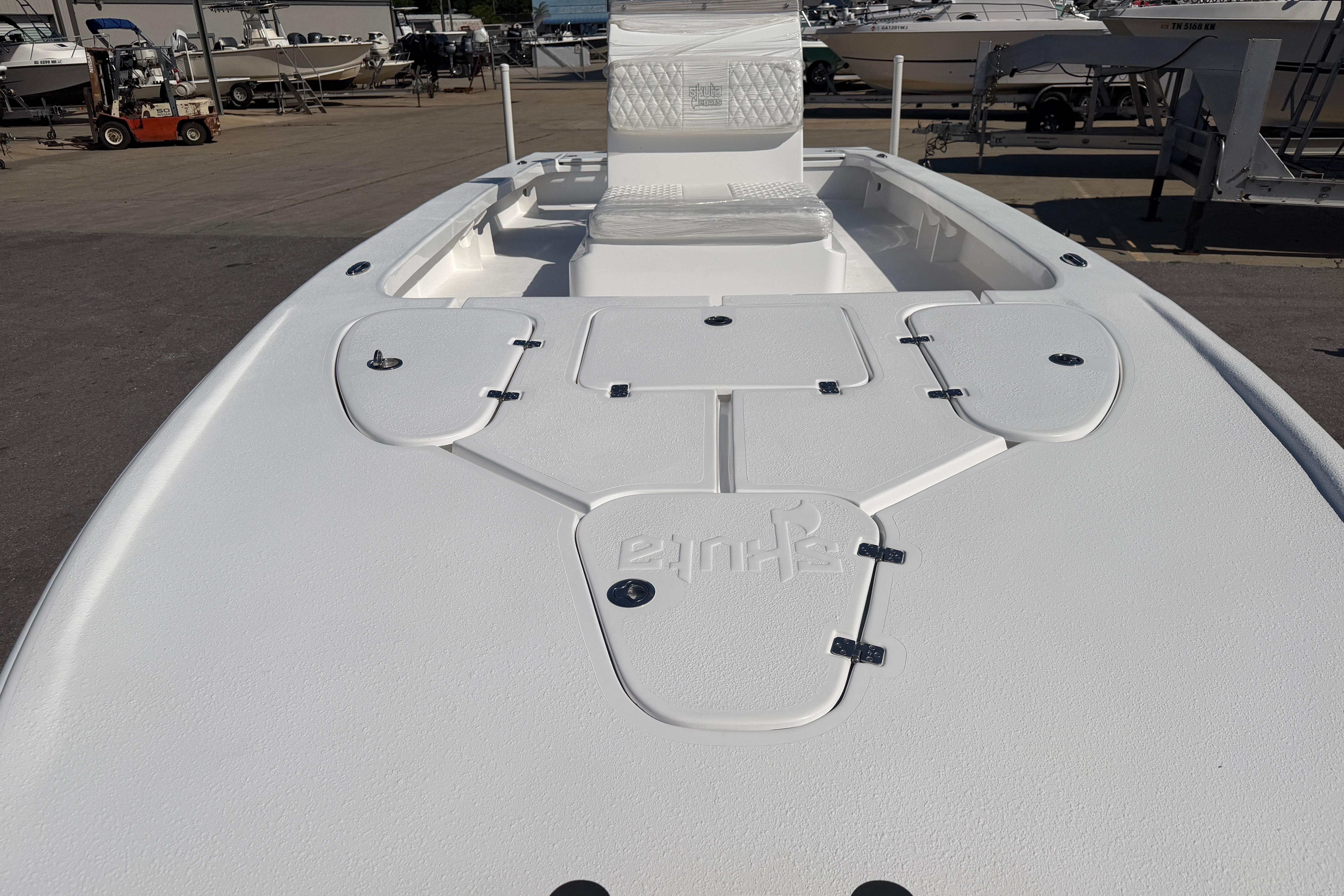 White Skuta 24 Cat boat deck, 2026 model, with storage compartments and seating.
