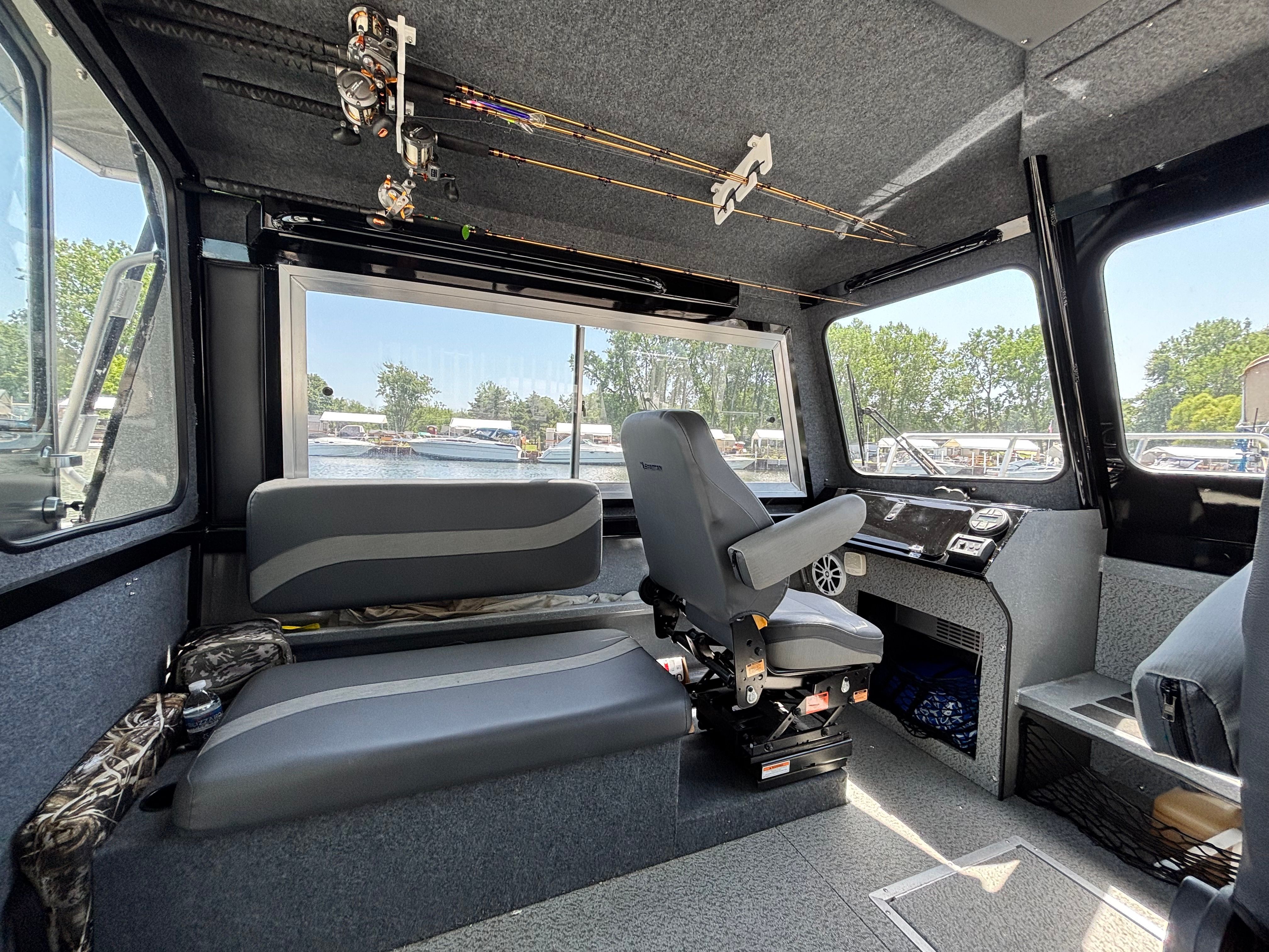 Interior of a Spartan 240 Maximus boat with seating and fishing rods.