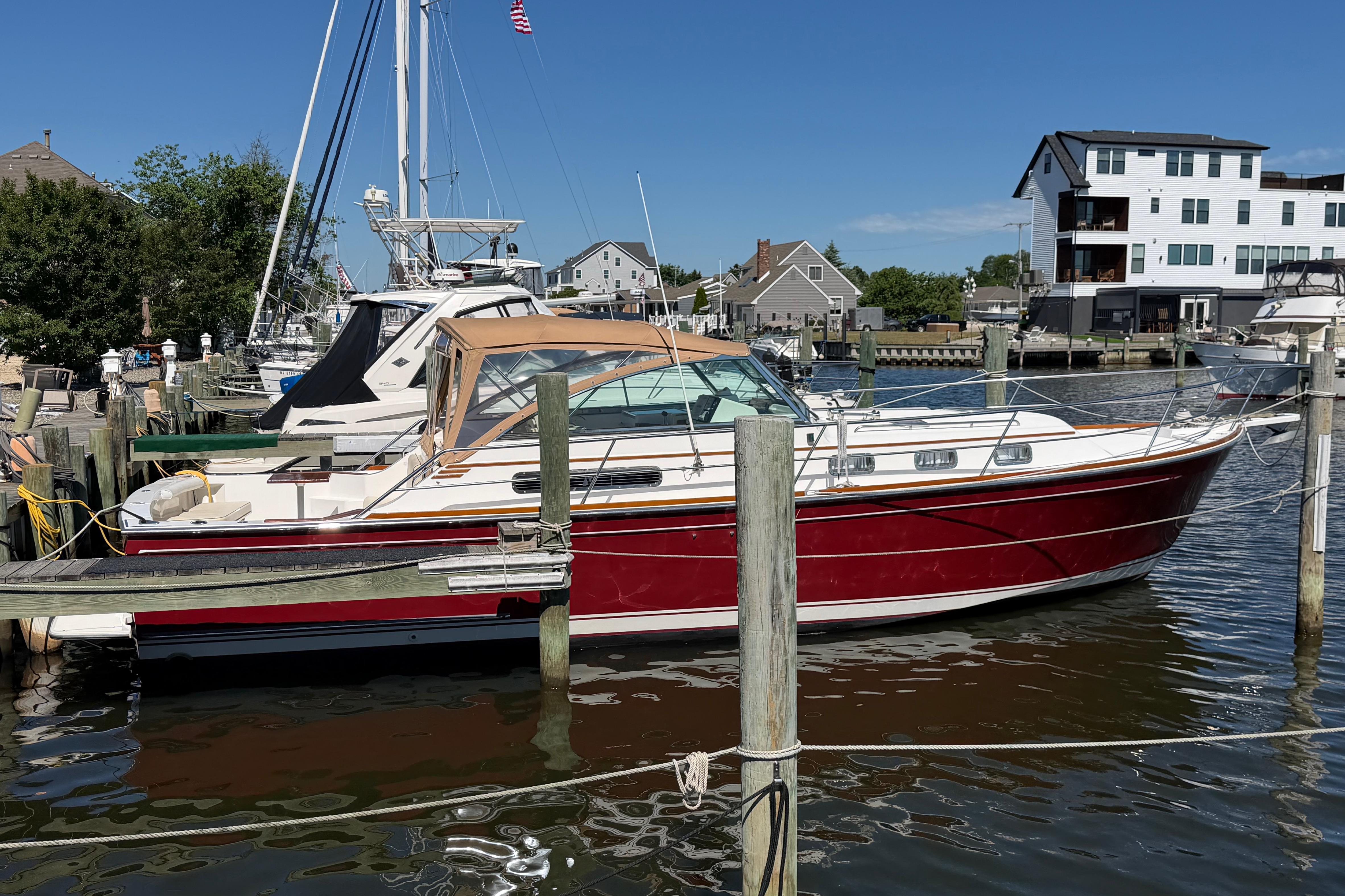 2000 Sabreline 36 Express boat docked in a marina, surrounded by other vessels.