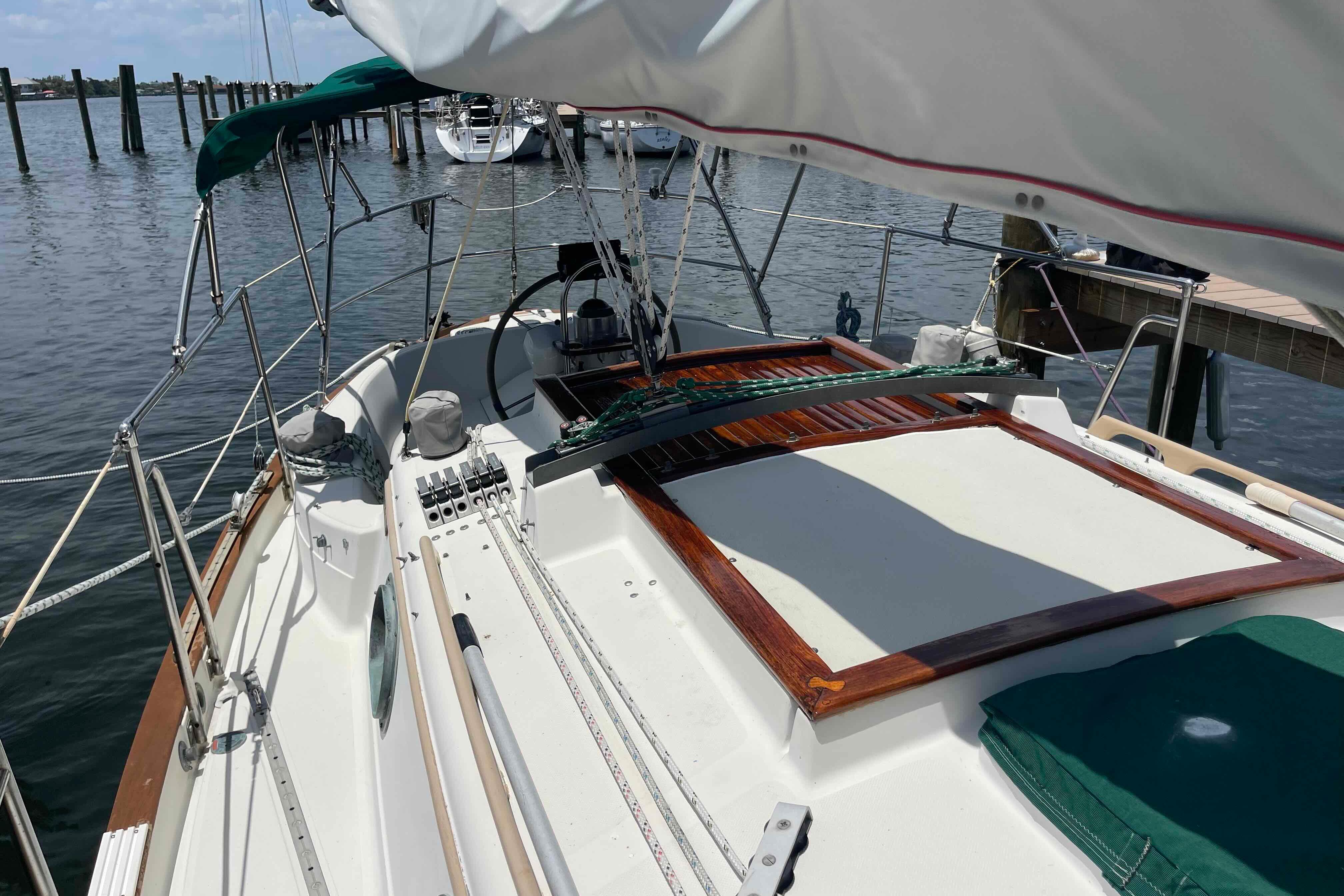 1987 Pacific Seacraft 34 sailboat deck view, docked at marina with clear skies.