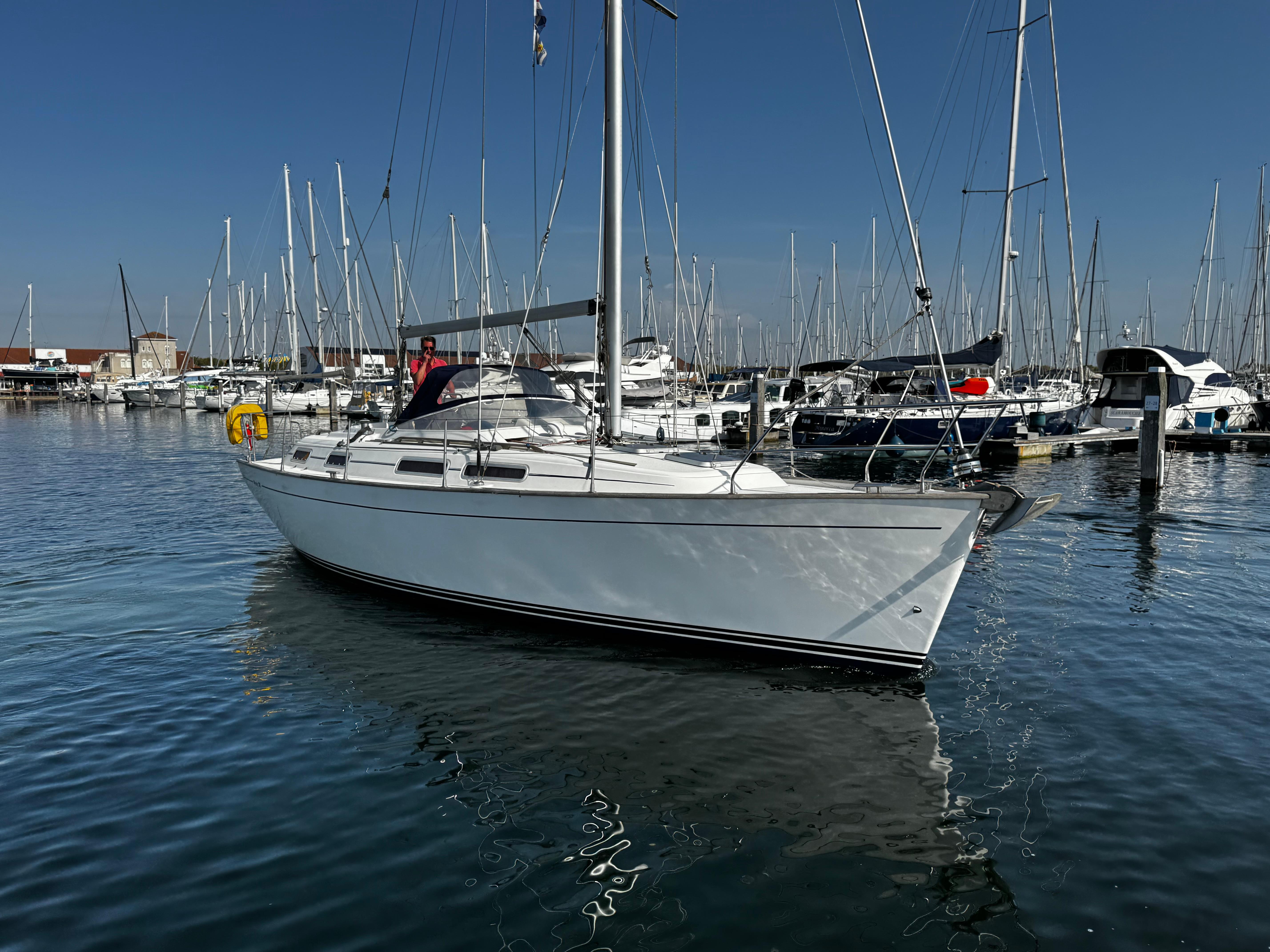 Sailboat Moody 36 CC 1996 docked in a marina under clear blue skies.