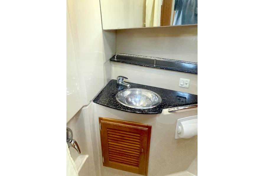 2016 Ranger Tugs R-31 bathroom with sink, mirror, and storage cabinet.