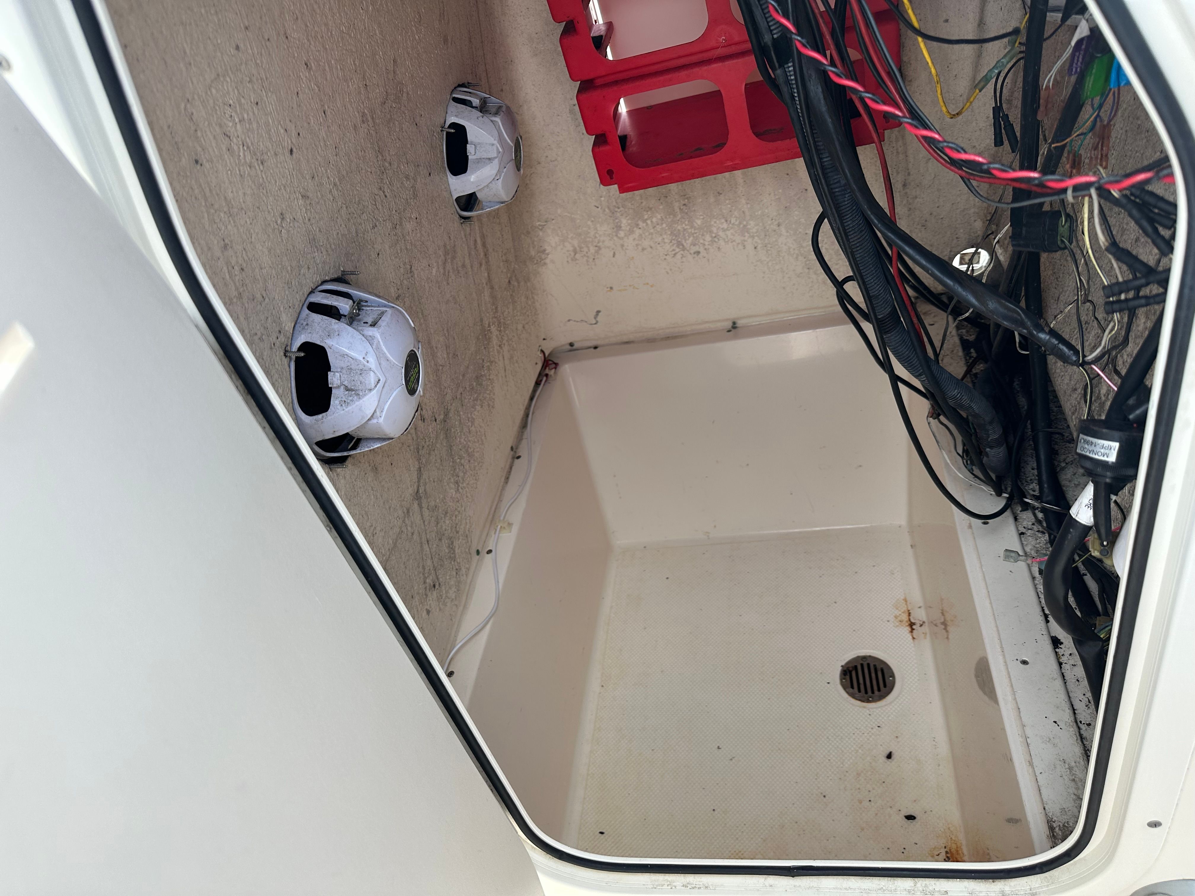 An open storage compartment with speakers and wires on the side.