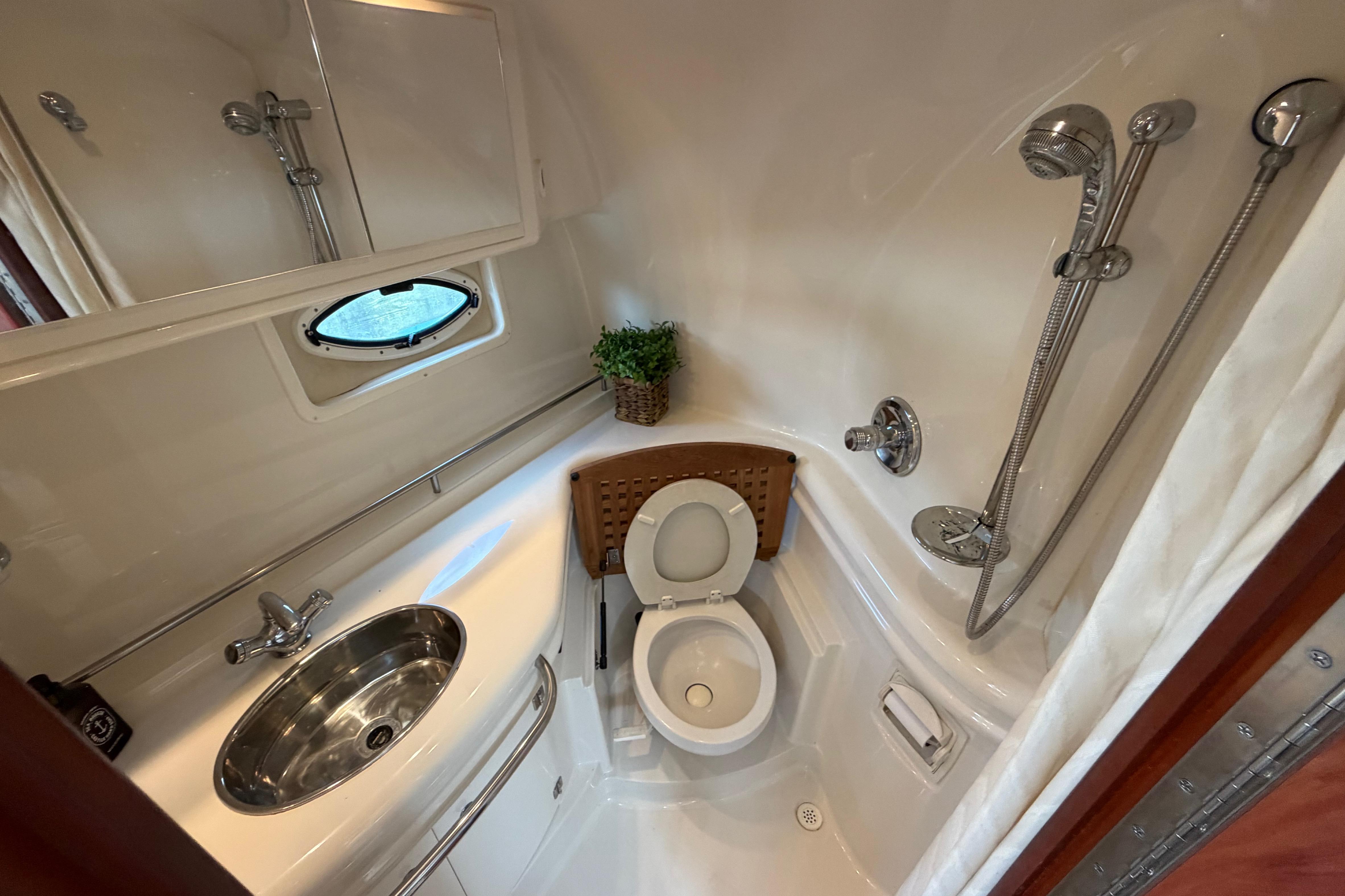 Compact bathroom in 2007 Monterey 350 Sport Yacht with shower, sink, and toilet.