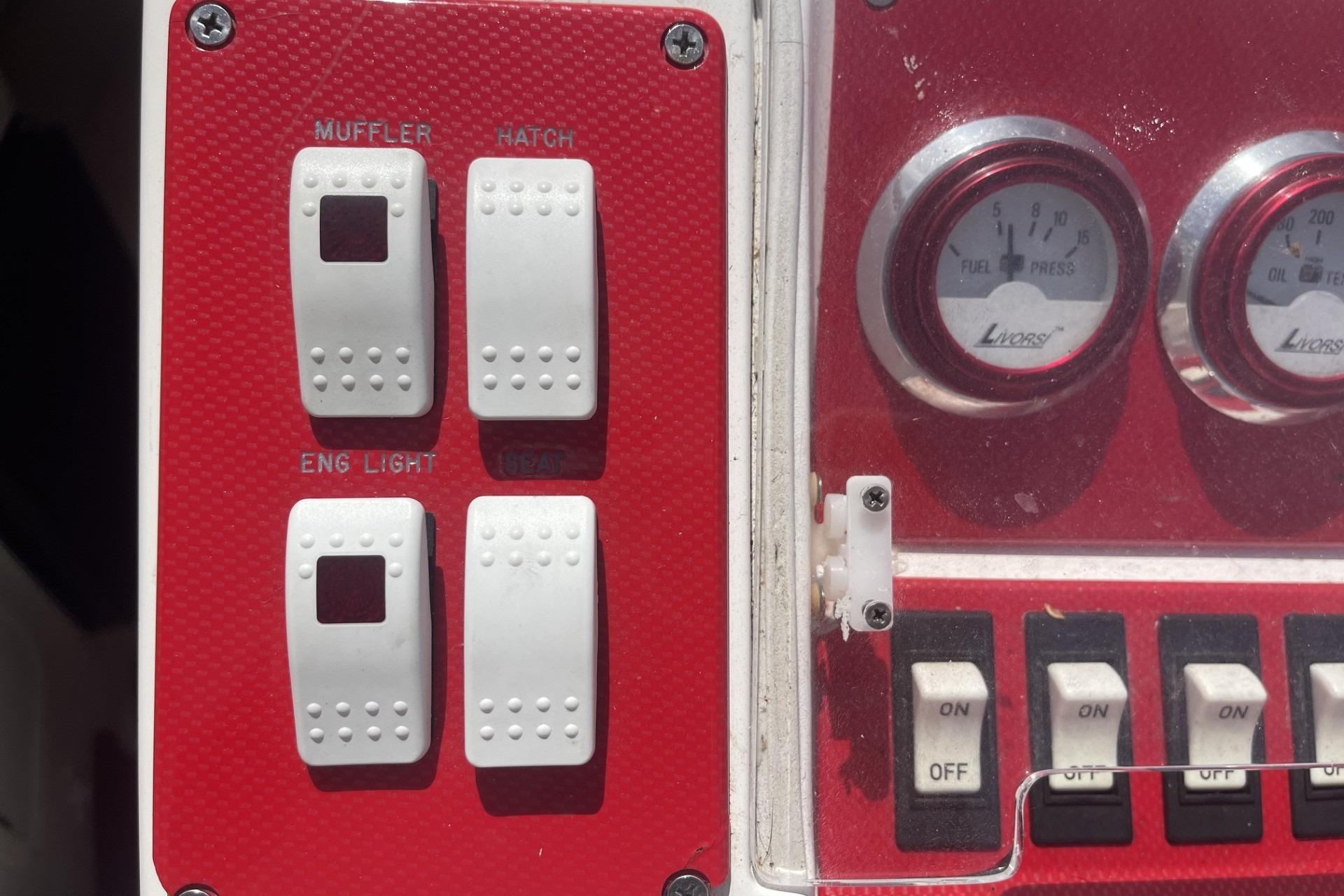 Control panel of a 2006 Sonic 386 boat with switches and gauges.