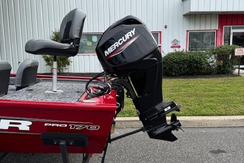 2026 Tracker Pro 170 boat with Mercury outboard motor, parked near a building.
