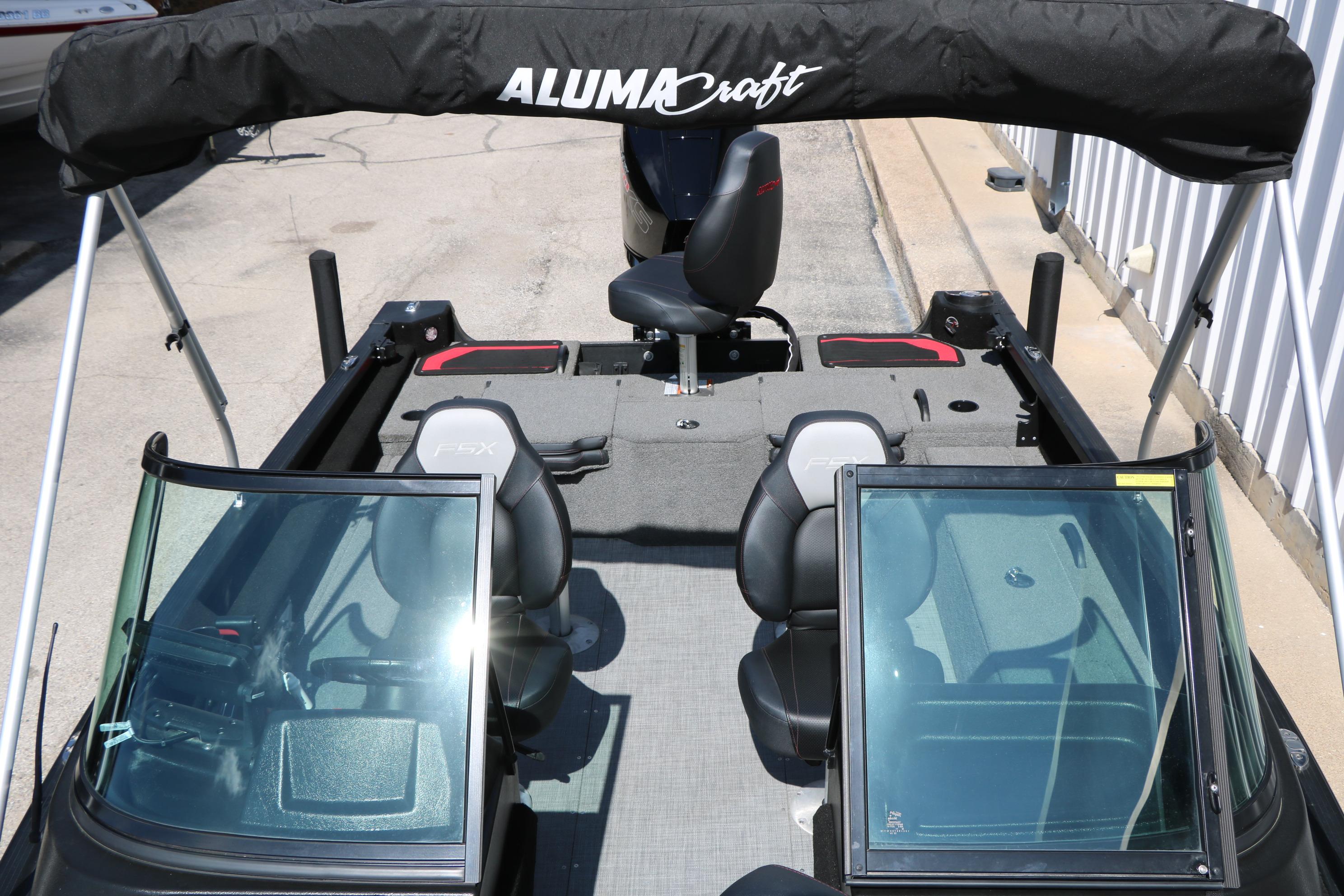 2023 Alumacraft Competitor FSX 185 boat interior with seating and windshield, featuring a bimini top.