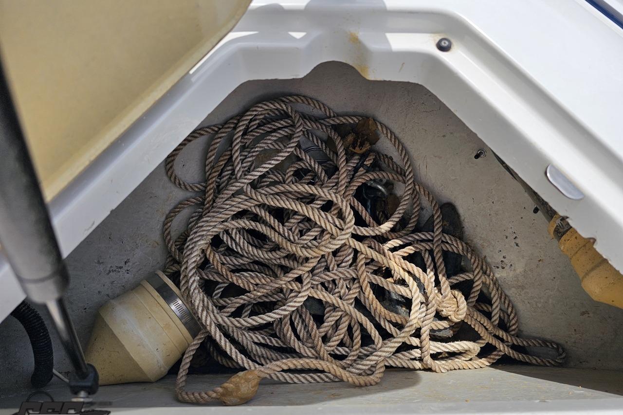 Storage compartment of a 2010 Cobalt 232 WSS boat with coiled rope and equipment.