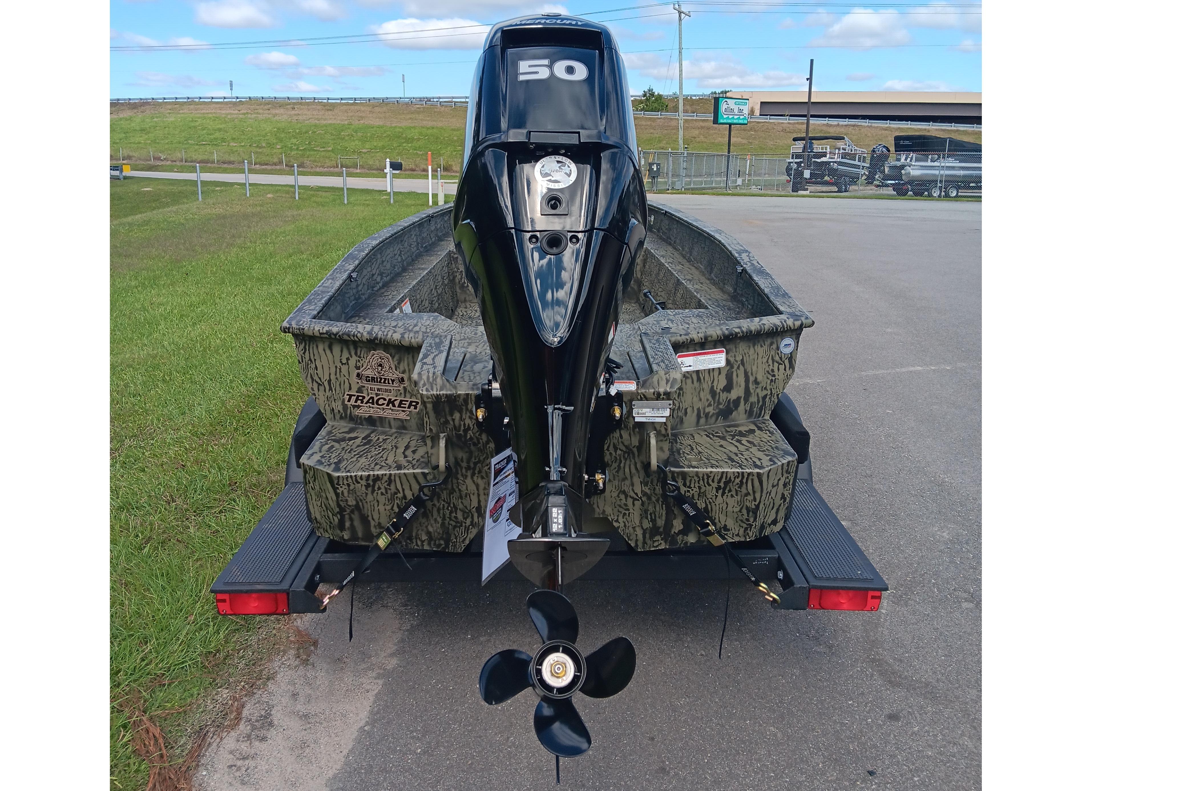 2026 Tracker Grizzly 1650 T Prairie Wings Edition boat with camo design and outboard motor.