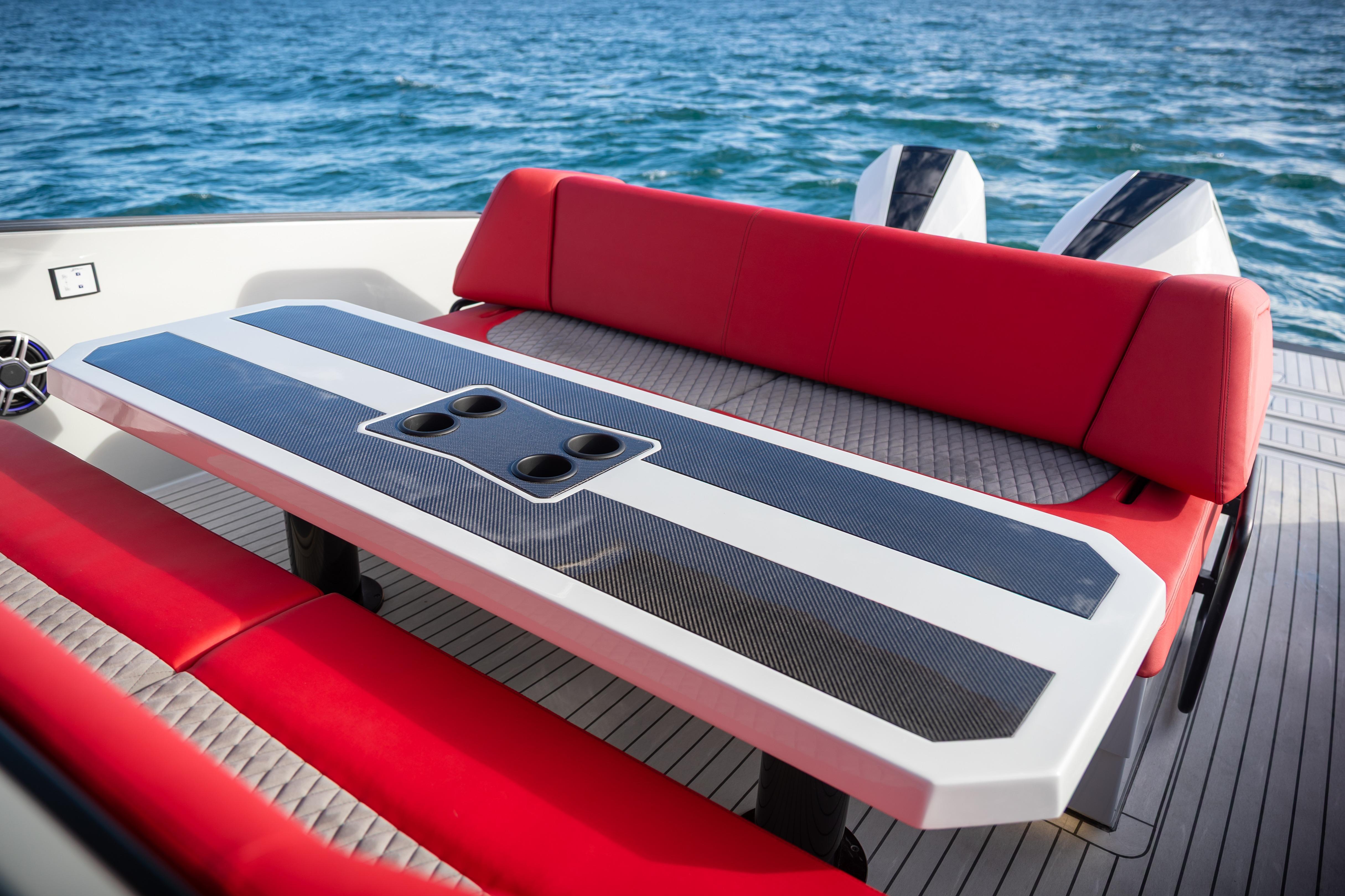 Tesoro 40 GTS 2026 boat with red seating and table on the water.