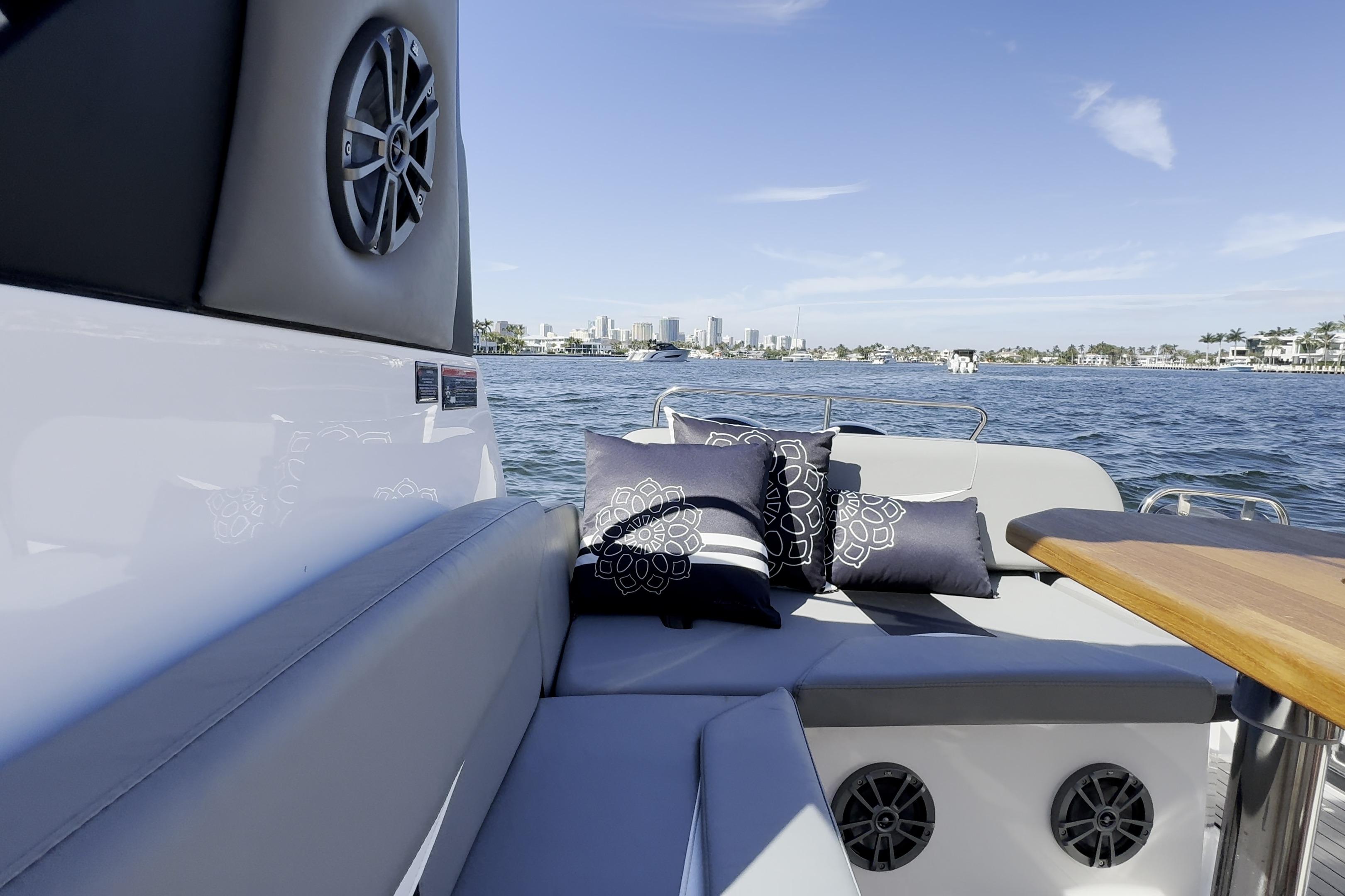 Luxurious Hanover 305 boat interior with cushions, overlooking a scenic waterfront view.