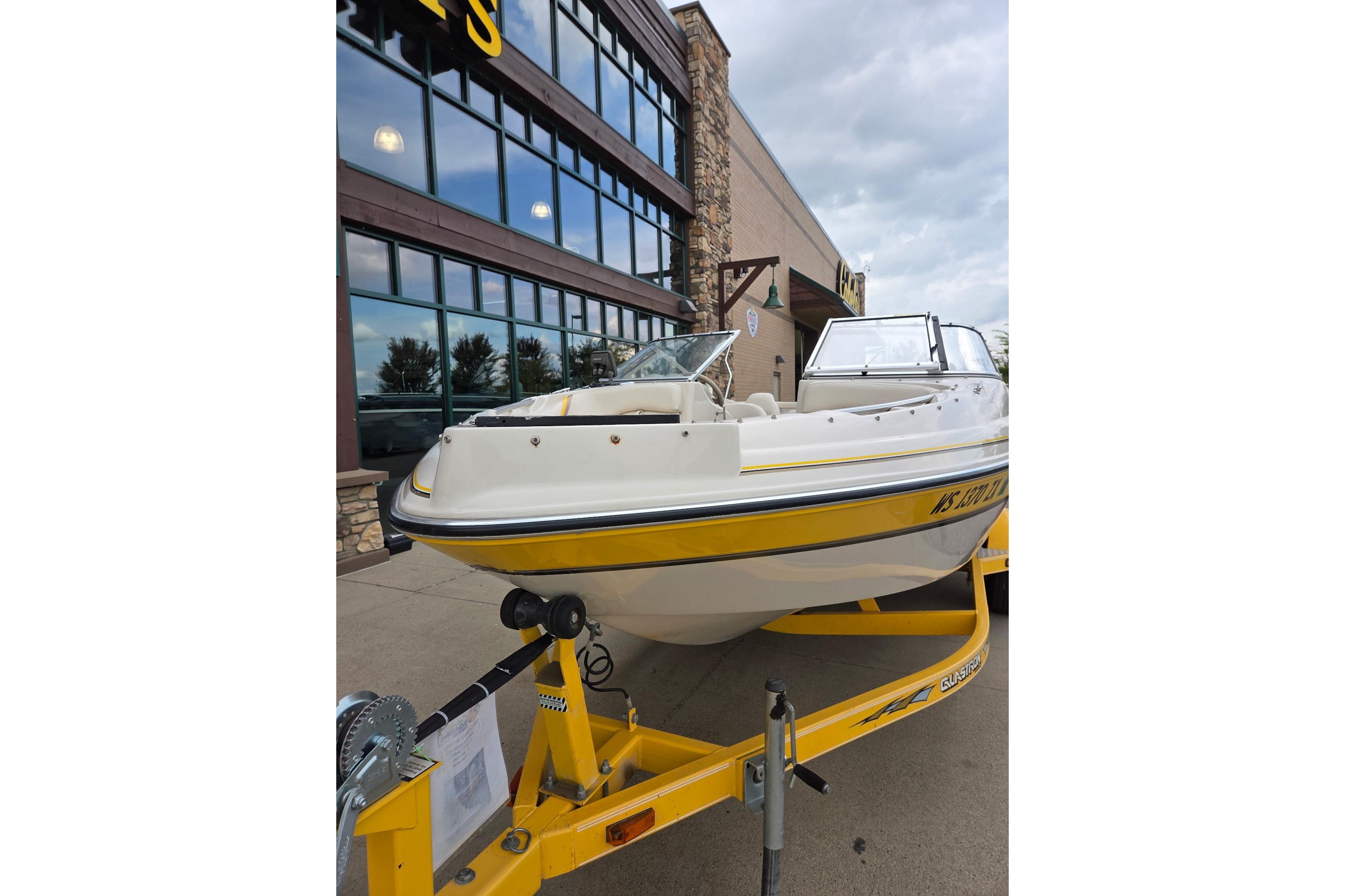 2003 Glastron GX185SF boat on yellow trailer outside a building.