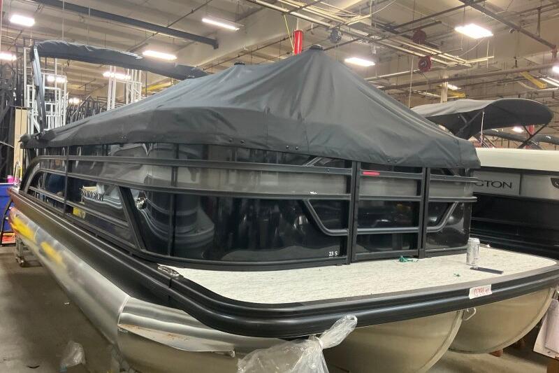 2026 Bennington 23 SSRSF pontoon boat with cover in a warehouse setting.