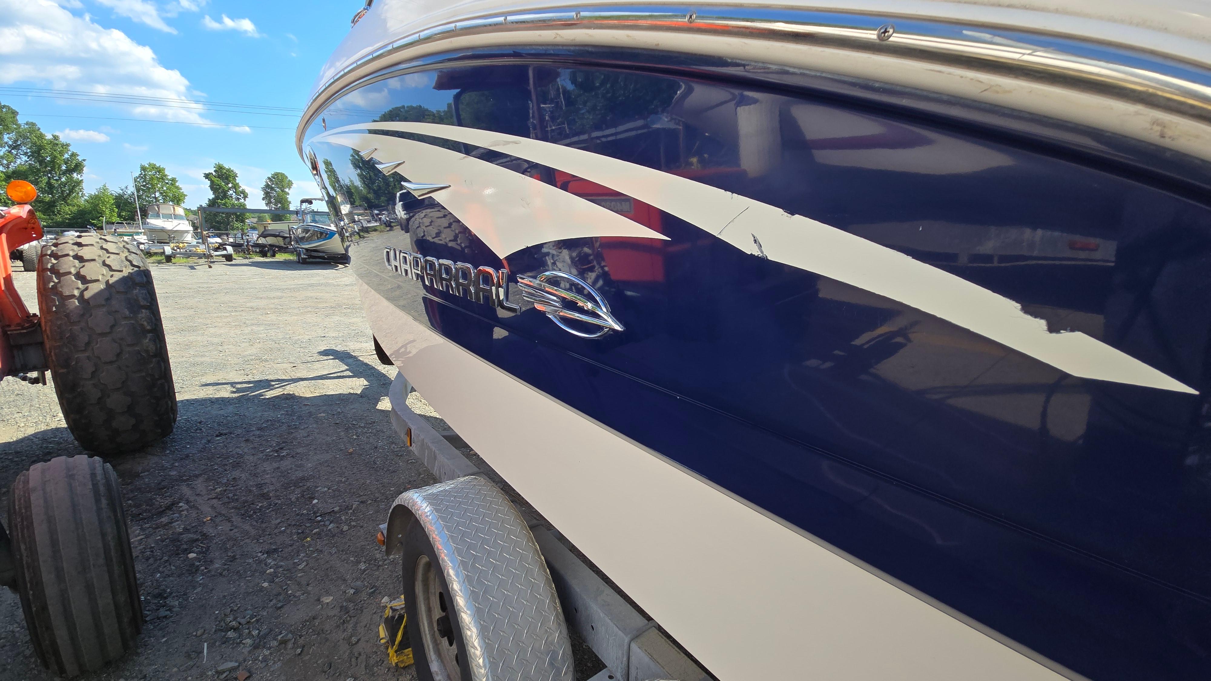 2018 Chaparral 224 Sunesta boat on trailer, blue and white design, parked outdoors.