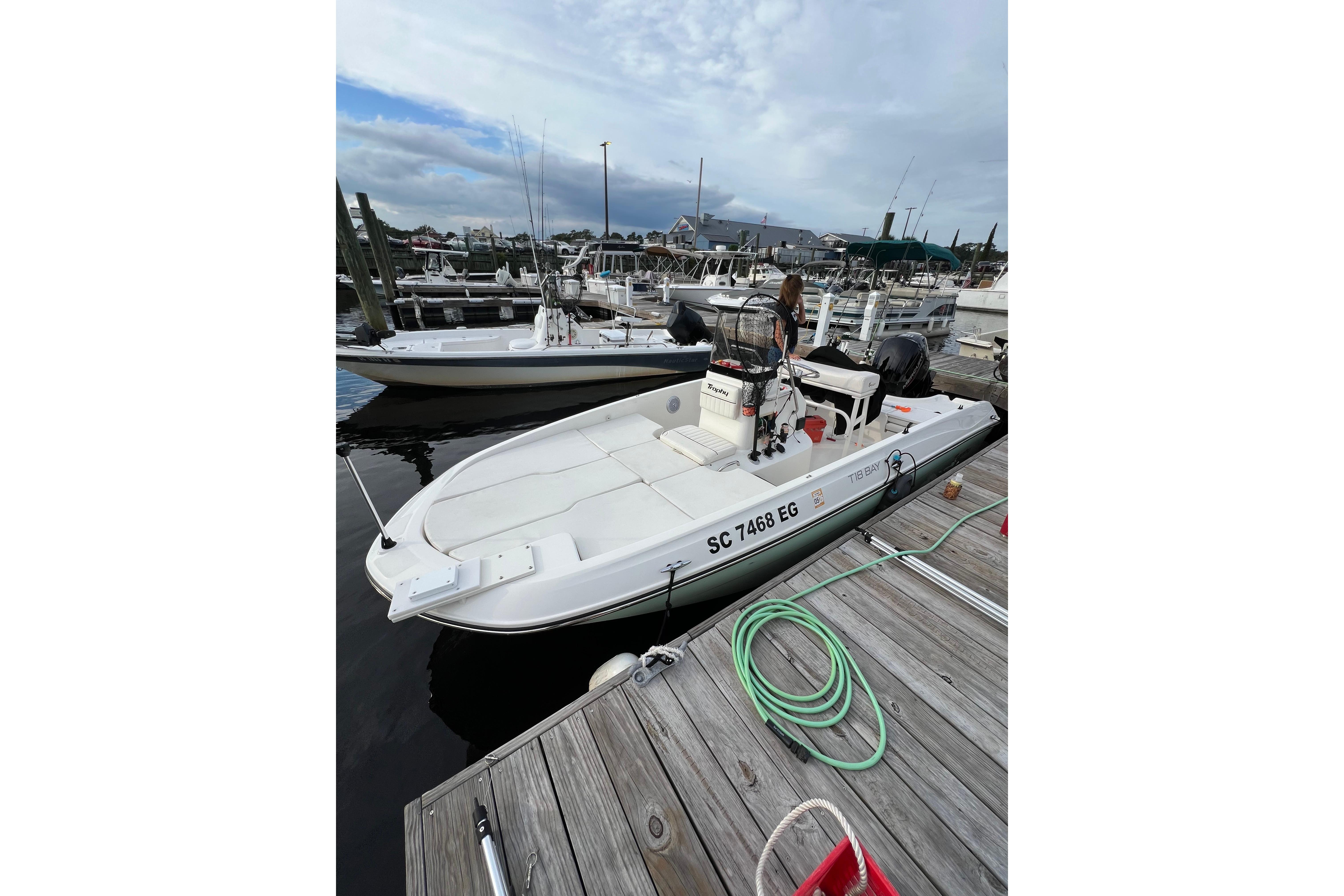 2023 Trophy T-18 boat docked at marina, overcast sky, wooden pier.