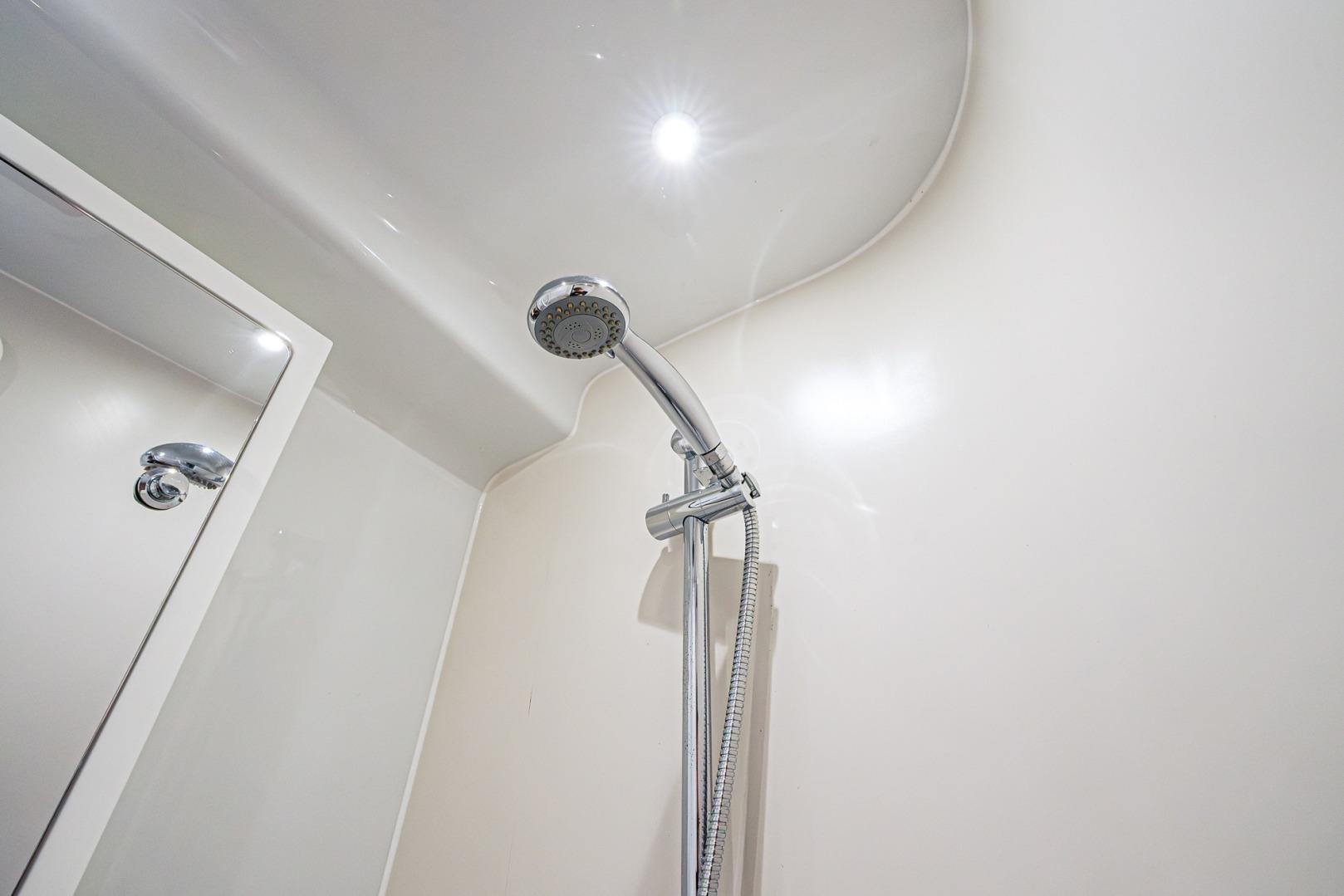 Shower area in 2024 Yellowfin 54 Offshore boat, featuring modern chrome fixtures.