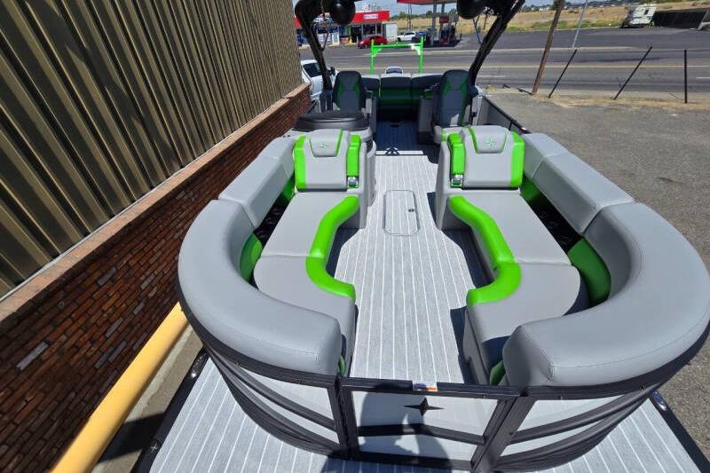 2026 Berkshire STS Arch Performance Series boat with gray and green seating, docked outdoors.