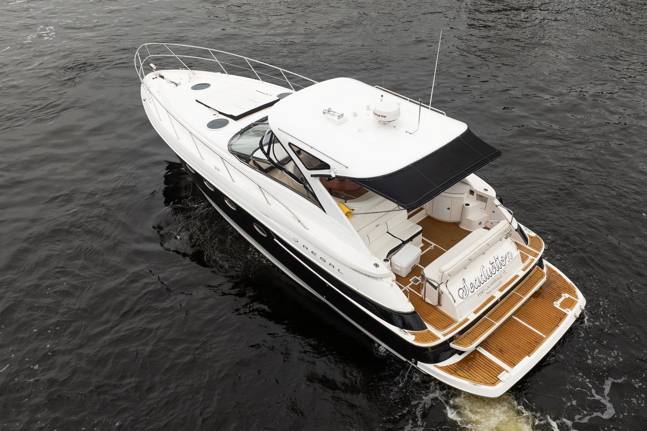 2008 Regal Commodore 4460 yacht cruising on dark water, aerial view.