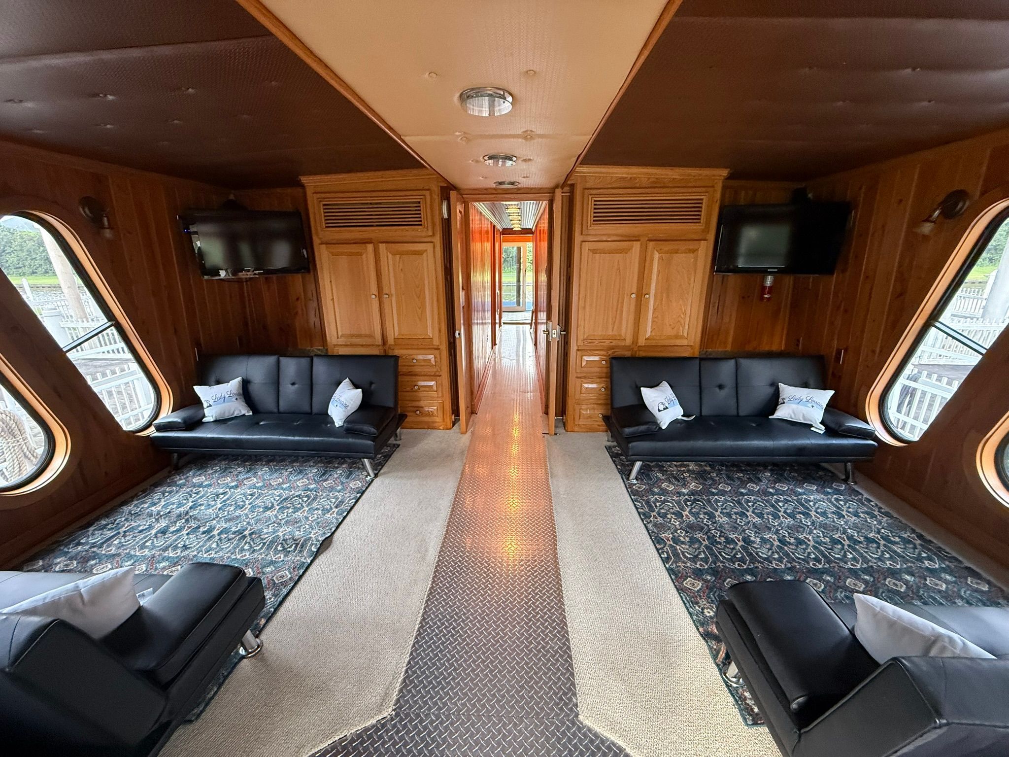 Luxurious interior with wood paneling, black sofas, and carpets.