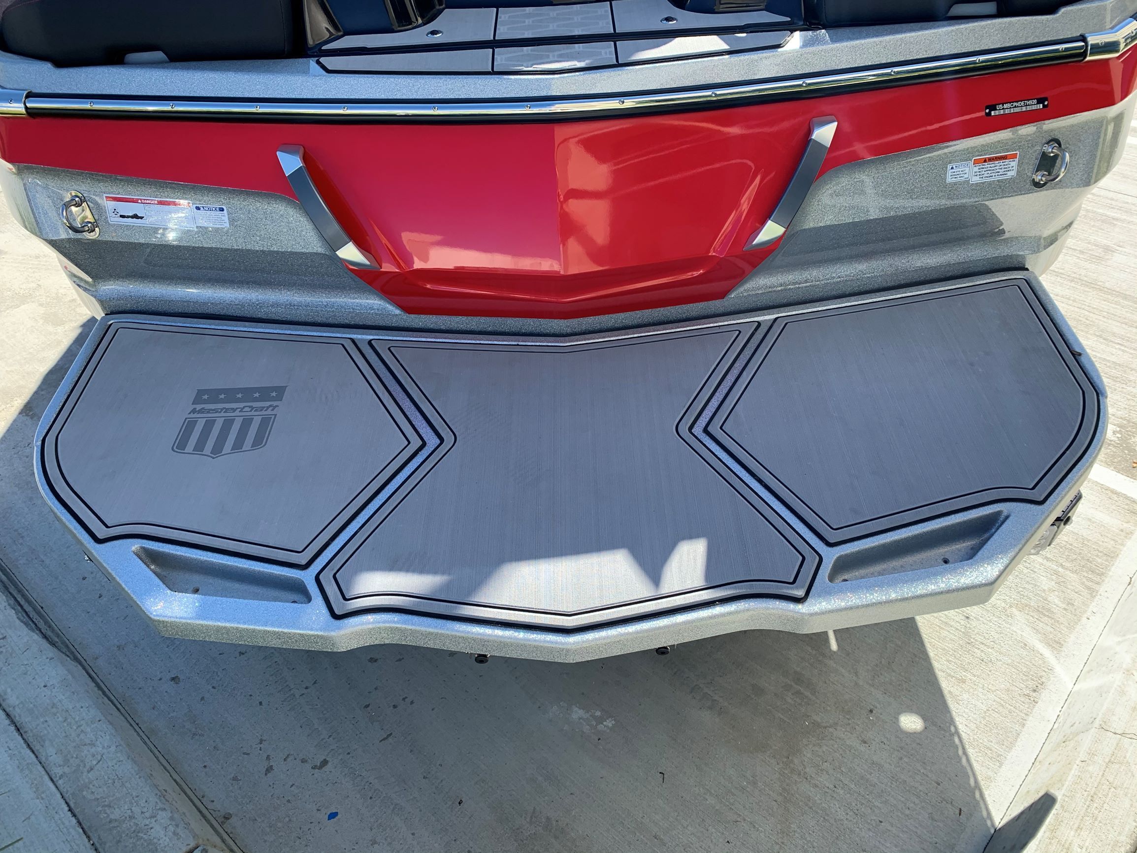 The image shows the rear of a 2020 MasterCraft X24 boat with a gray platform.