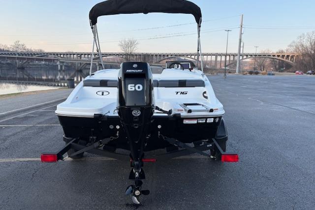2026 Tahoe T16 boat with Mercury 60 engine, parked near a bridge.