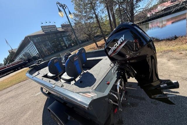 2026 Ranger VS1665SC boat with Mercury engine near a lakeside building.