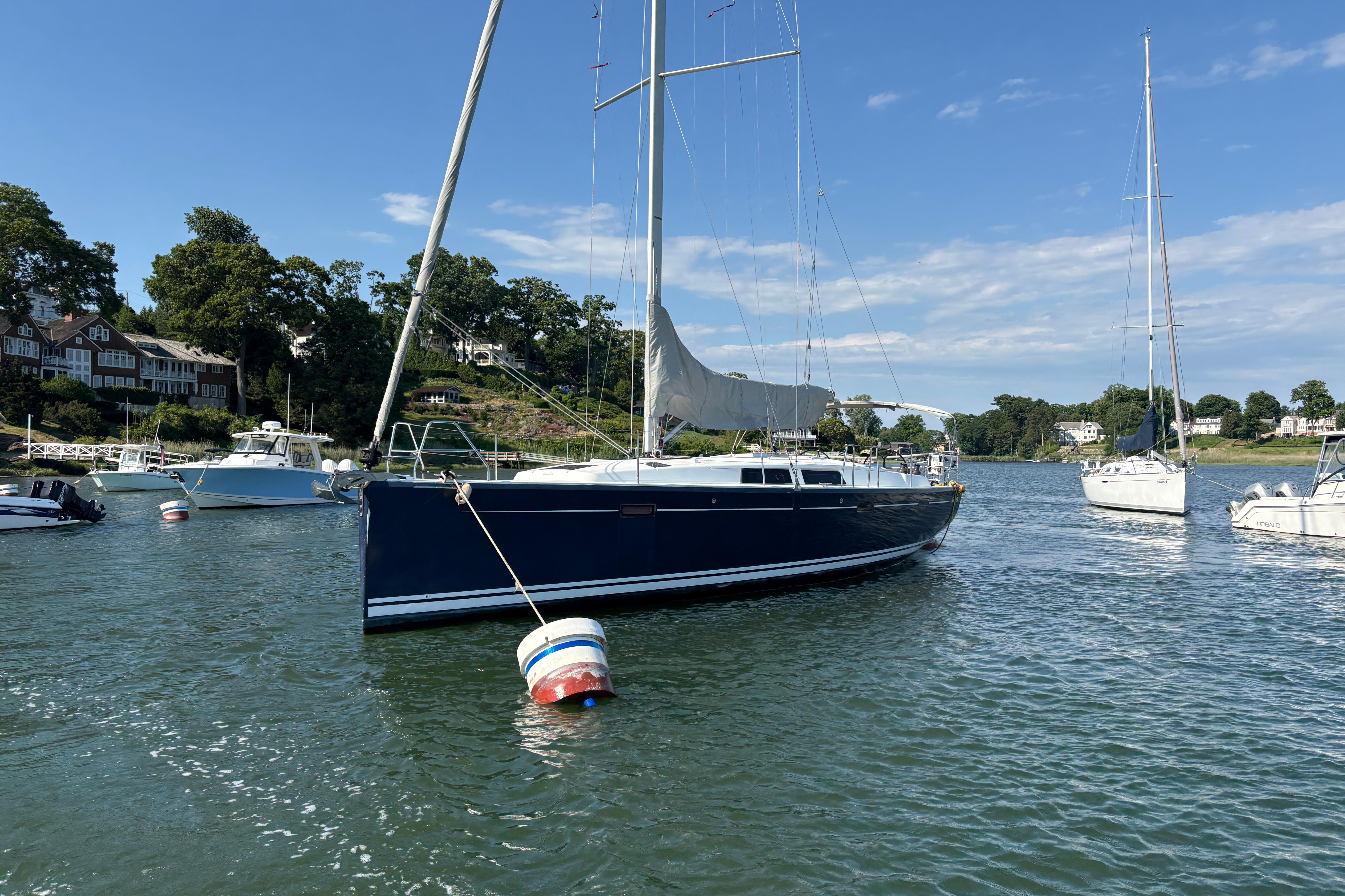 Sailboat Hanse 415 (2014) anchored in a scenic harbor with other boats.