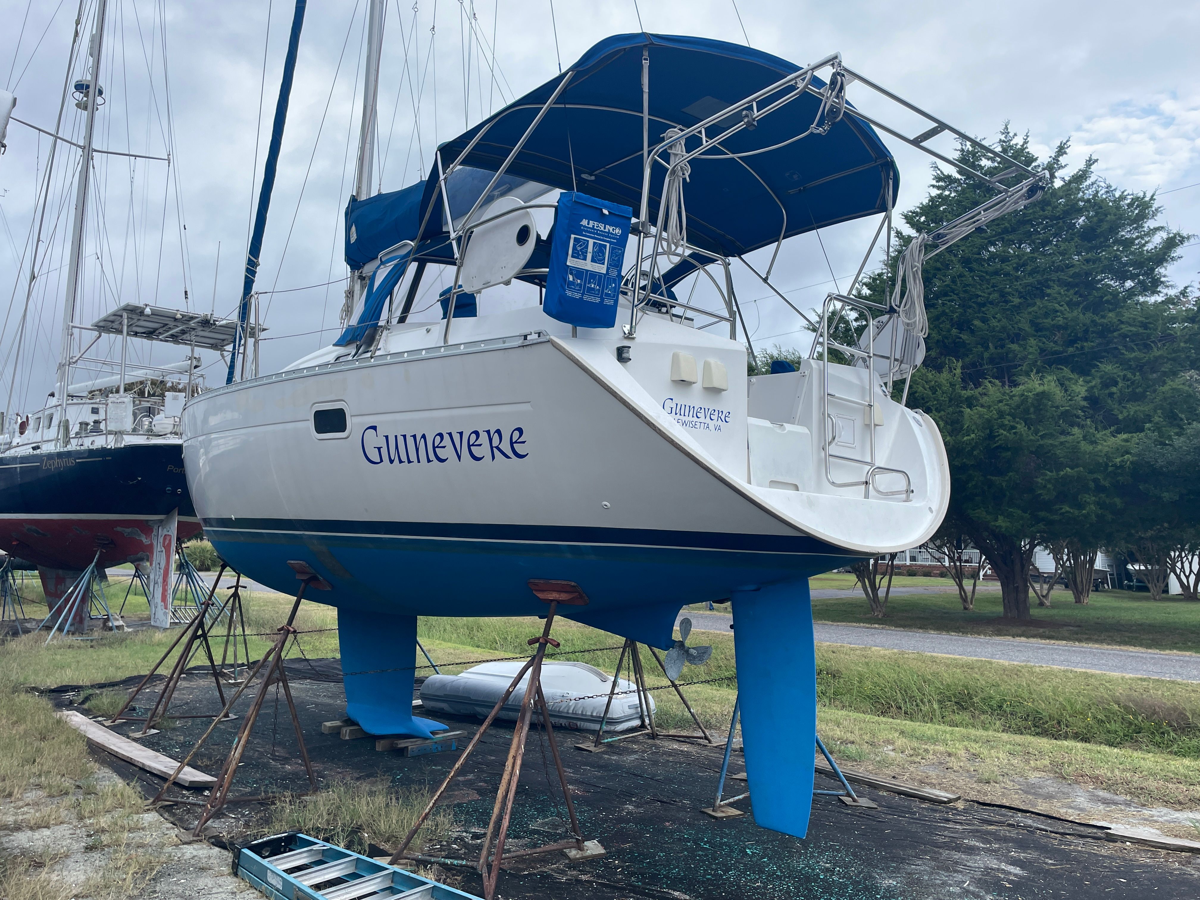 A 2000 Beneteau Oceanis 361 is on dry dock. It features a blue sunshade.
