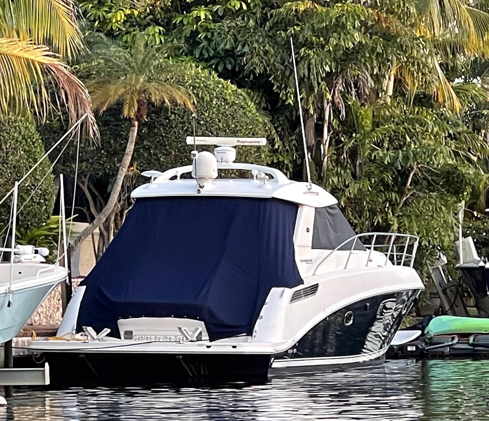 2010 Sea Ray 450 yacht docked in tropical harbor.