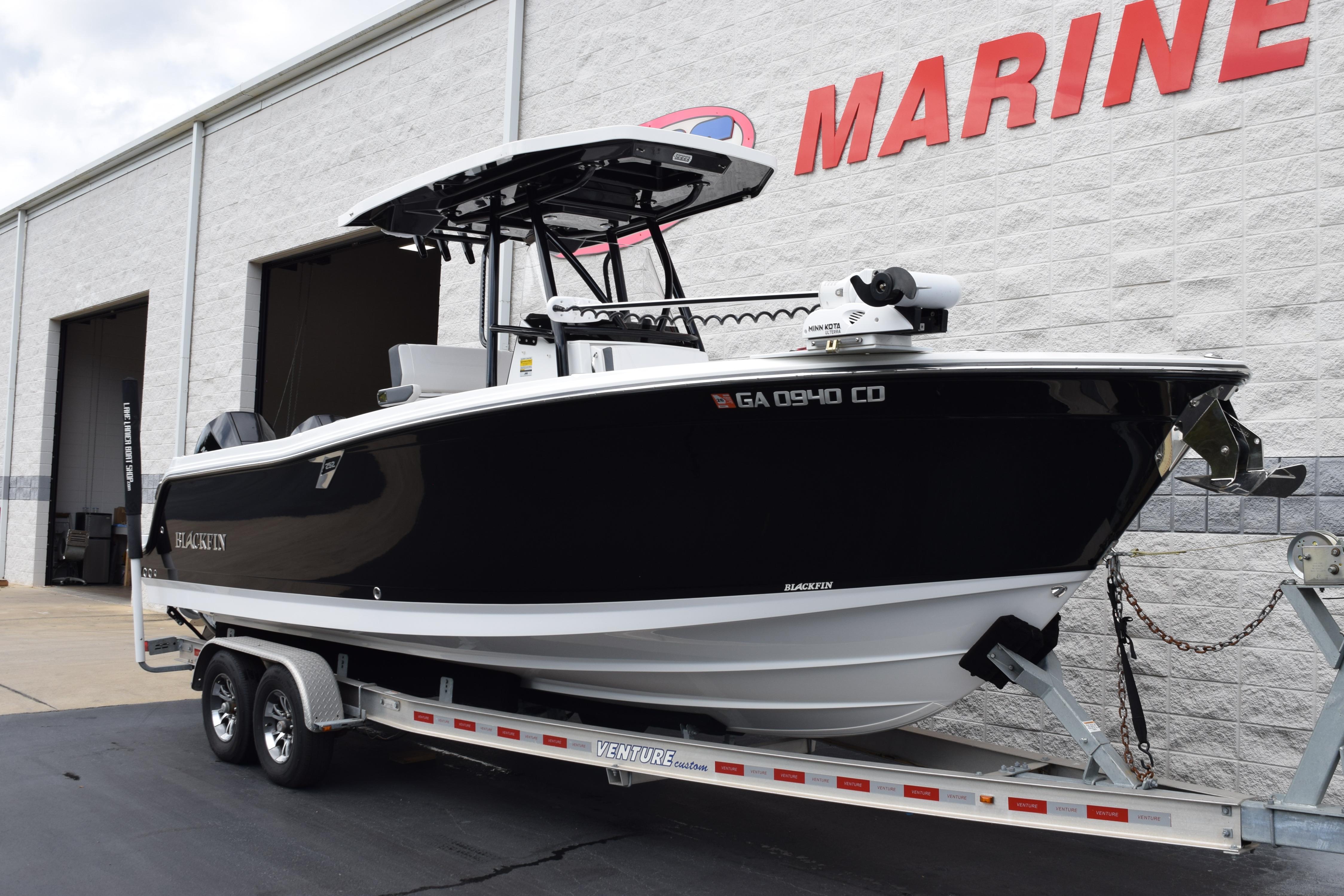 2023 Blackfin 252 CC boat on trailer outside marine dealership.