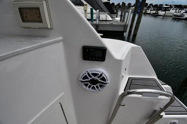 2021 Regal 35 Sport Coupe boat with speaker and control panel at marina.