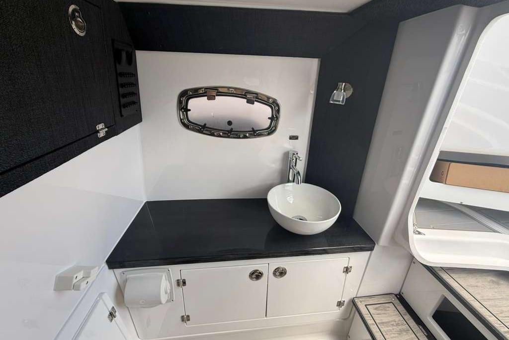 Modern bathroom interior of 2026 Monterey Elite 30 OB boat, featuring sleek sink and cabinetry.