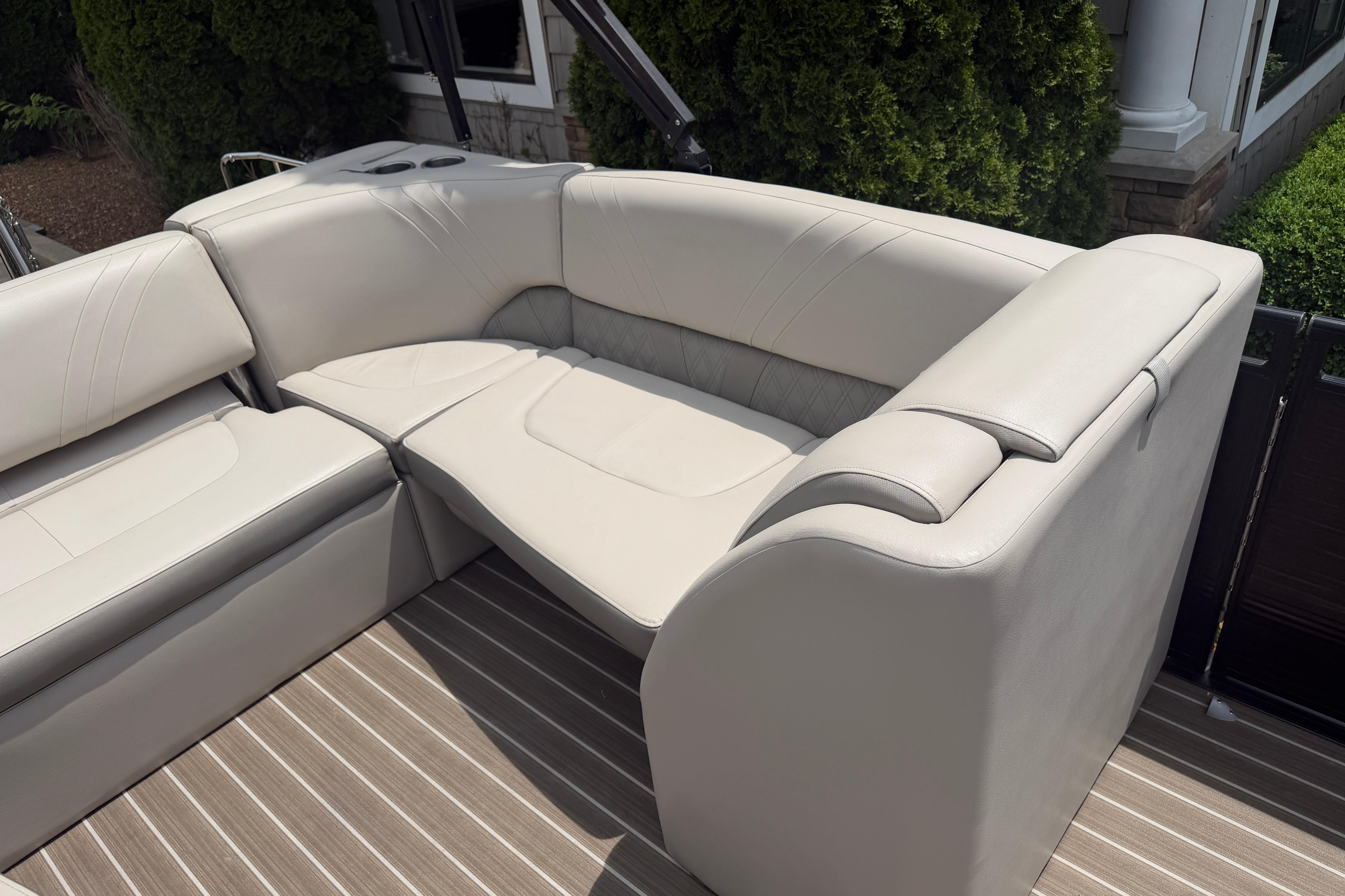 2019 Harris Solstice 240 boat interior with plush beige seating and striped flooring.
