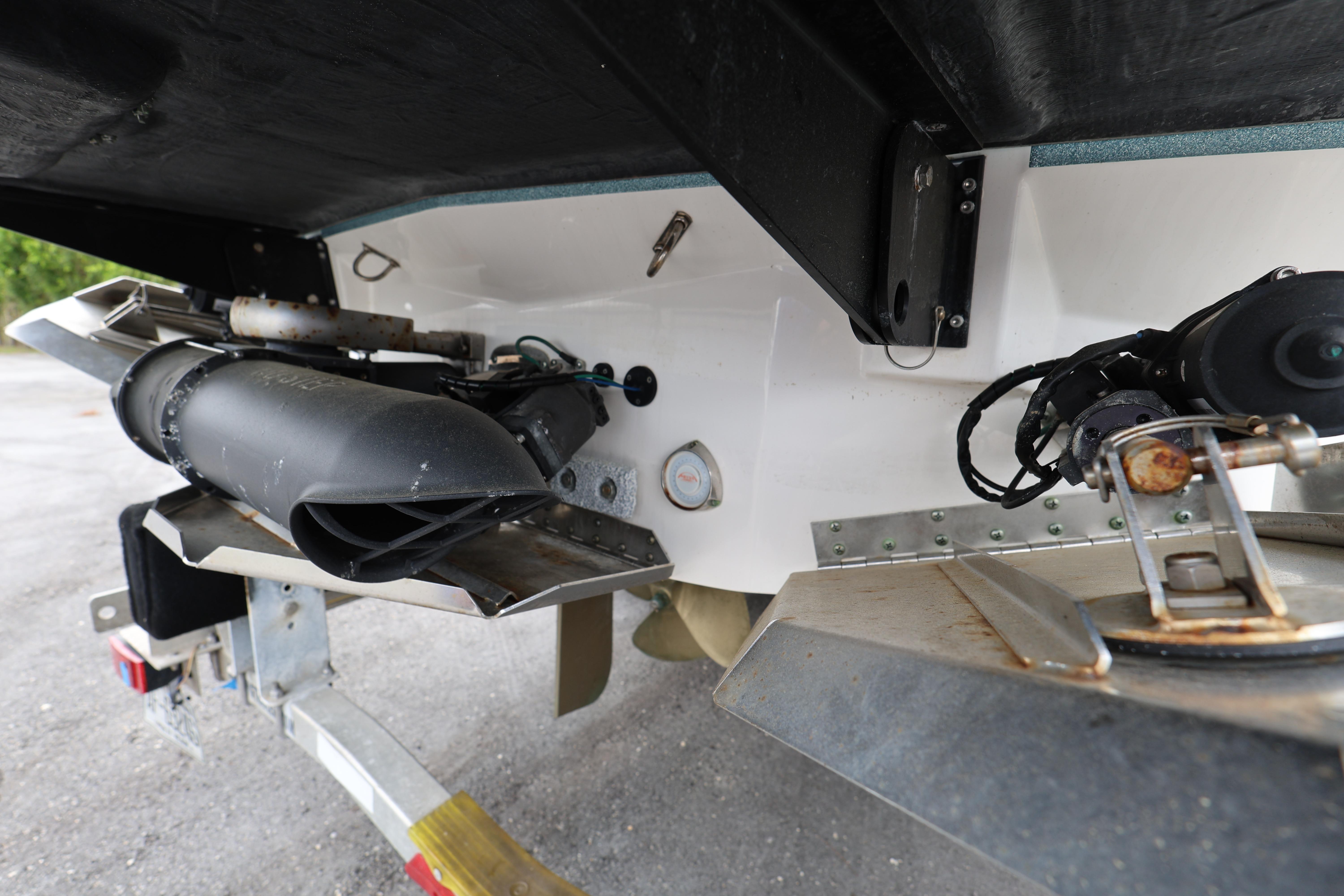 Rear view of a 2023 MasterCraft X24 boat's propulsion system and trailer.